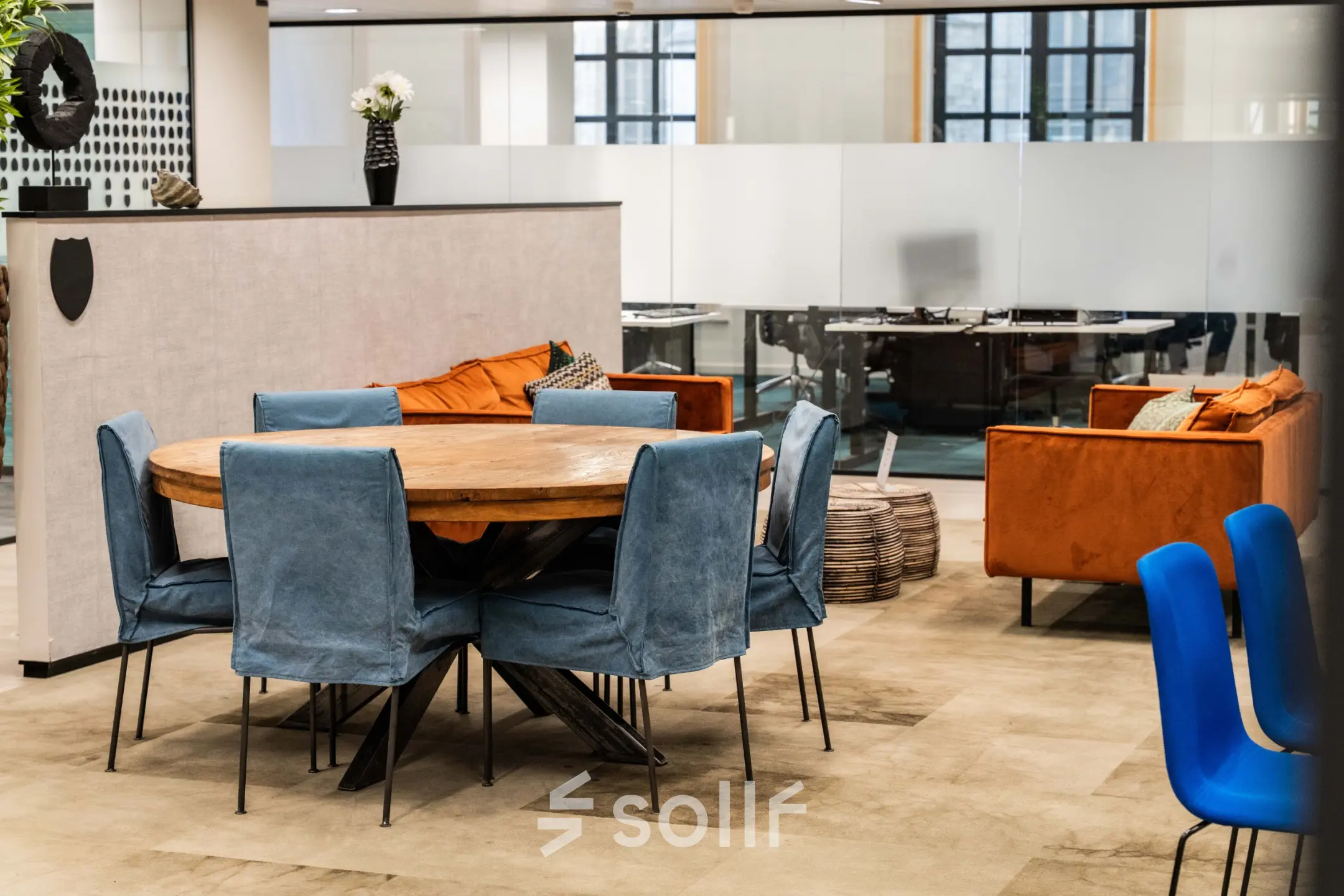 Moderne kantoorruimte te huur in Brussel Europese Wijk met stijlvolle, blauwe stoelen en een grote houten tafel. Perfect om kantoorruimte te huren op Rue des Colonies 56.