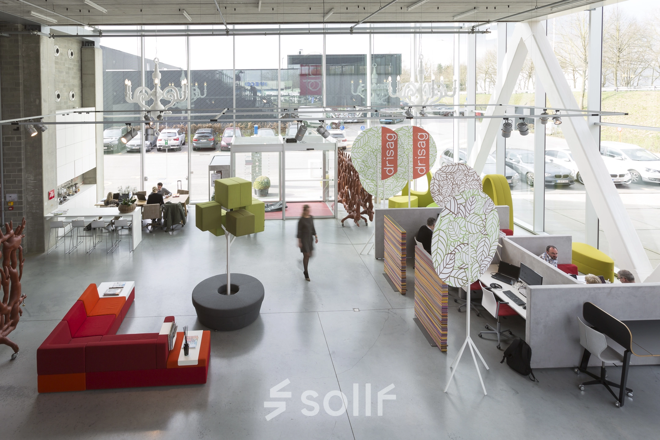 Moderne kantoorruimte te huur in Herentals, met kleurrijk interieur en flexibele werkplekken. Medewerkers bezig aan hun bureau en ontspannen loungehoek. Ruime ramen zorgen voor veel natuurlijk licht.