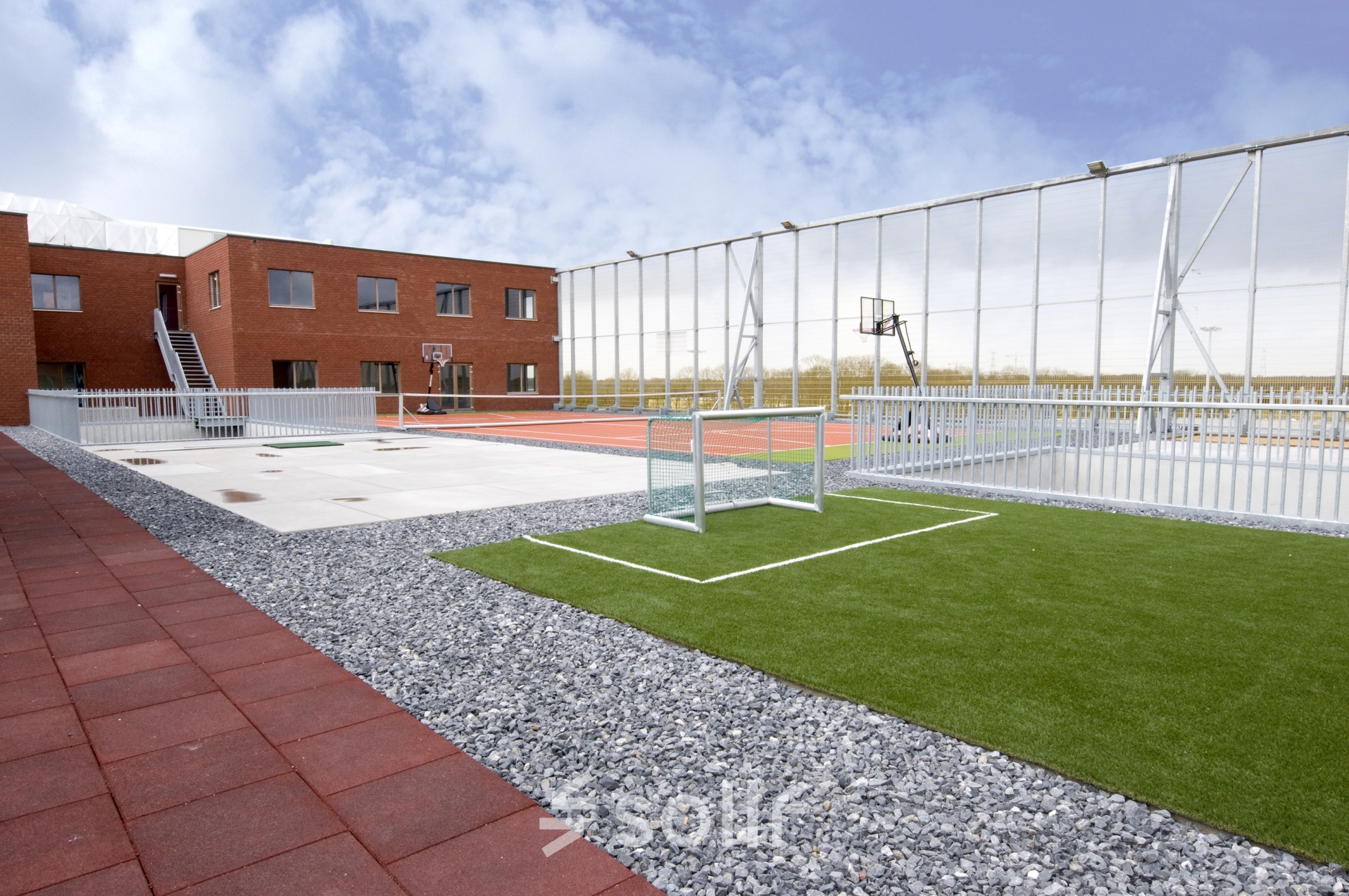 Buitenaanzicht van het gebouw op Diamantstraat 8, Herentals, met sportvelden en open lucht. Kantoorruimte te huur op een strategische locatie.