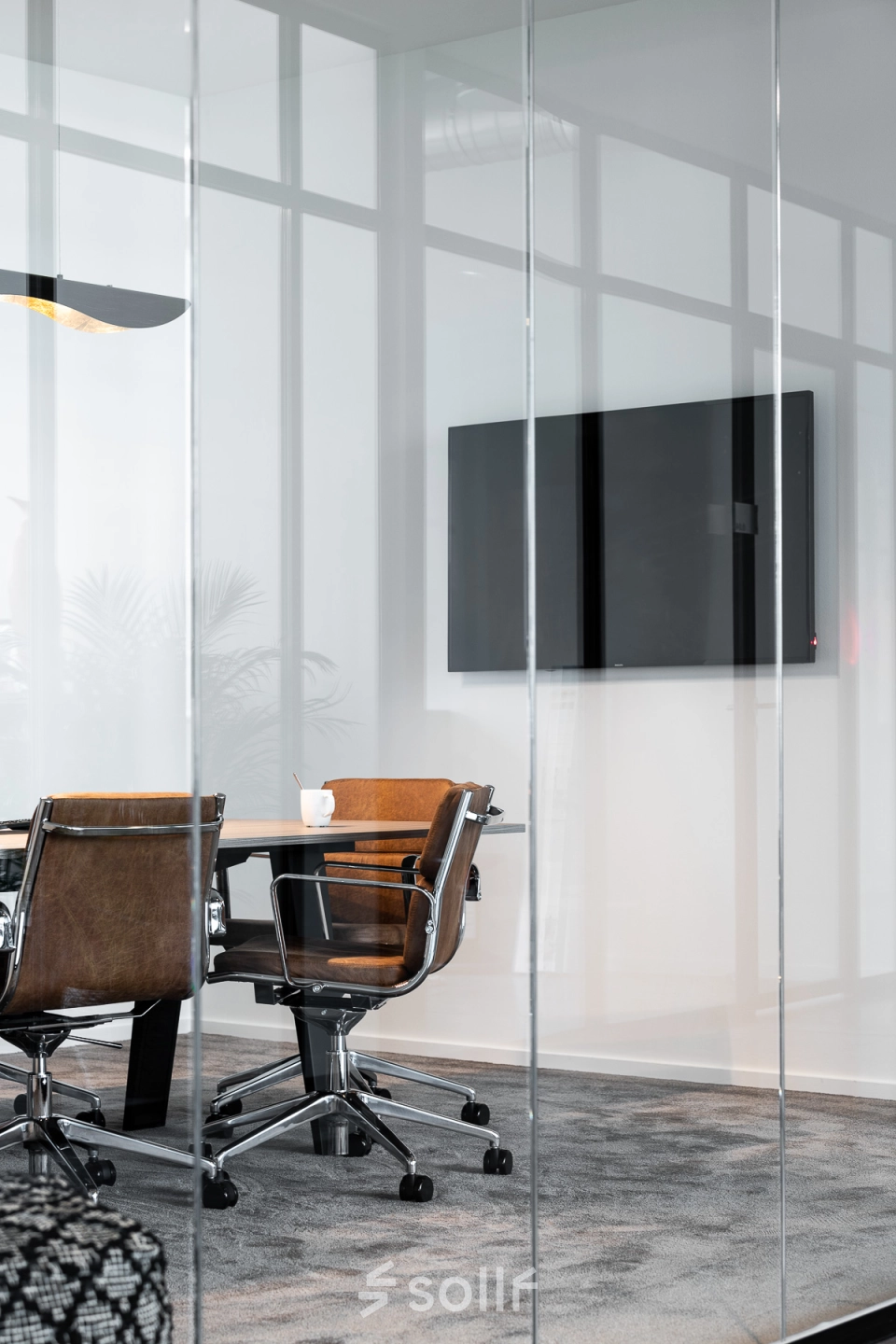 Stijlvolle, volledig ingerichte vergaderruimte met moderne stoelen en een grote flatscreen aan de muur. Perfect voor kantoor te huur op Philipssite 5 in Leuven, ideaal voor wie kantoorruimte wil huren.