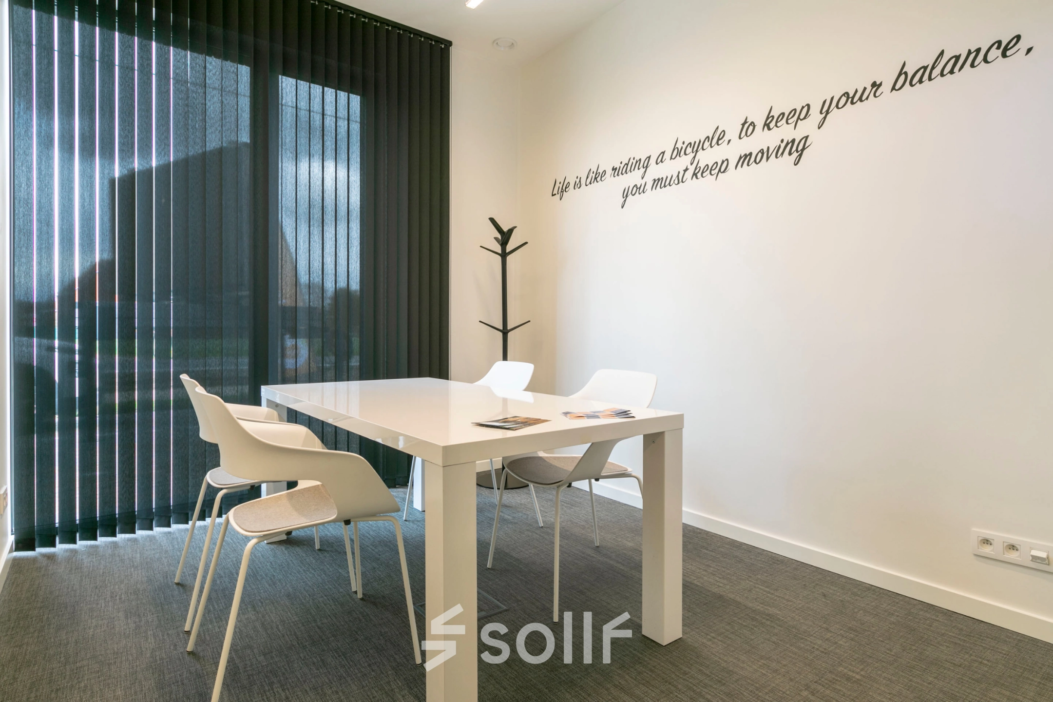 Moderne kantoorruimte te huur in Westerlo met strakke witte tafel en vier stoelen, ideaal voor zakelijke bijeenkomsten.