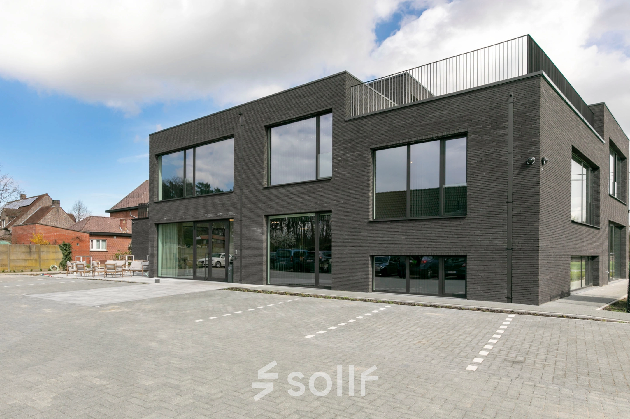 Modern kantoorgebouw te huur aan Olenseweg 375, Westerlo. Stijlvolle gevel met grote ramen, omgeven door parkeerplek. Perfecte locatie voor kantoorruimte huren.