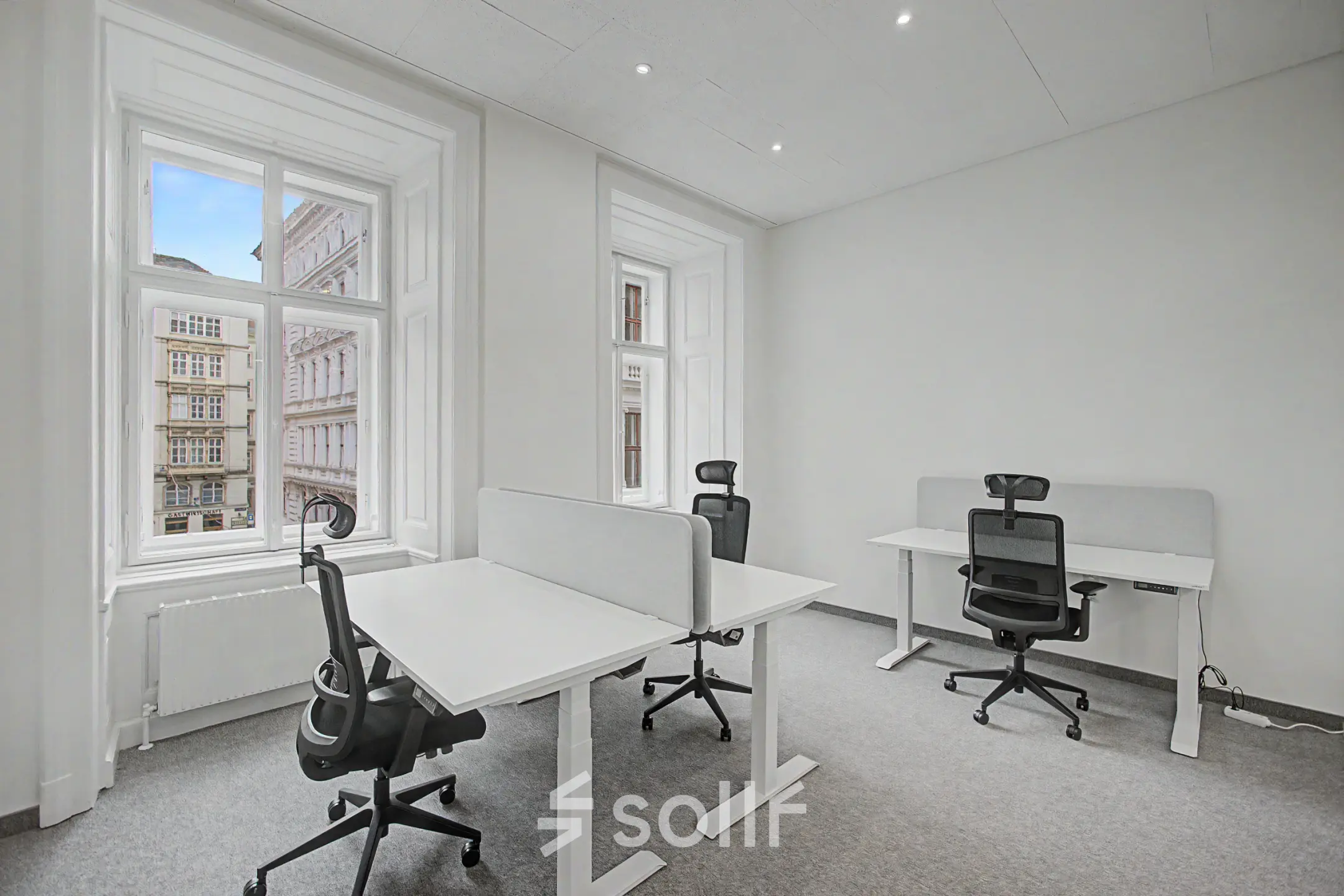 Helles Büro in Wollzeile 11, 1010 Wien mit großen Fenstern, zwei Schreibtischen und ergonomischen Stühlen. Ideal zum Büroraum mieten im Herzen der Inneren Stadt.