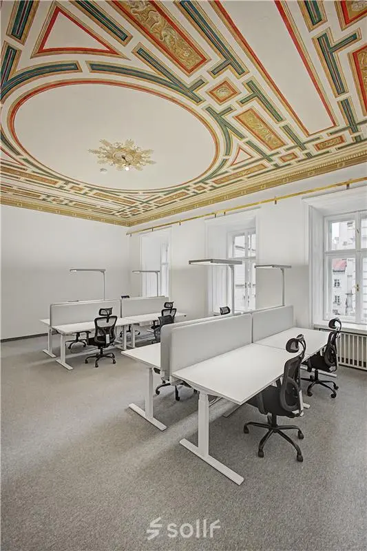 Elegante Bürofläche mieten in 1010 Wien mit dekorativer Decke und modernen Arbeitsplätzen, ideal für Kreativteams.