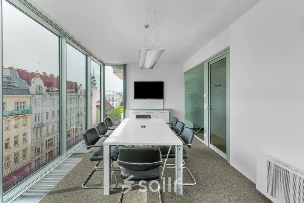 Modernes Büro in Wien mit großen Fenstern, Tisch, Stühlen und Bildschirm. Ideal, um Bürofläche zu mieten in der Mariahilfer Straße 36.