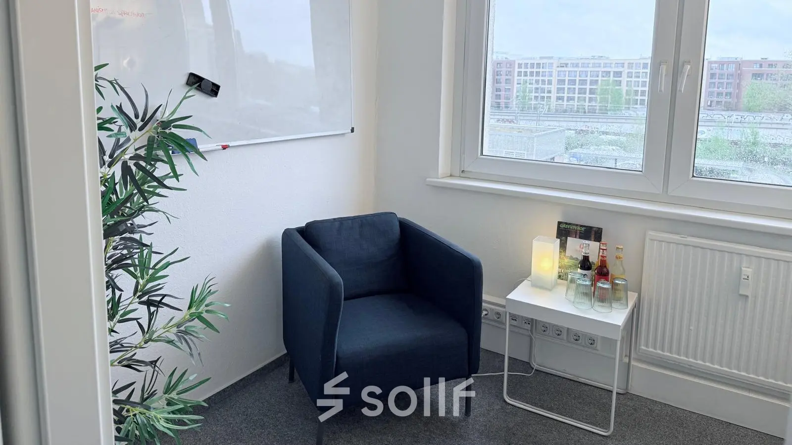 Kleiner Büroraum in Berlin Friedrichshain mit gemütlichem Sessel, Tisch und Whiteboard an der Wand. Perfekt geeignet, um ein Büro zu mieten oder Büroraum zu mieten.