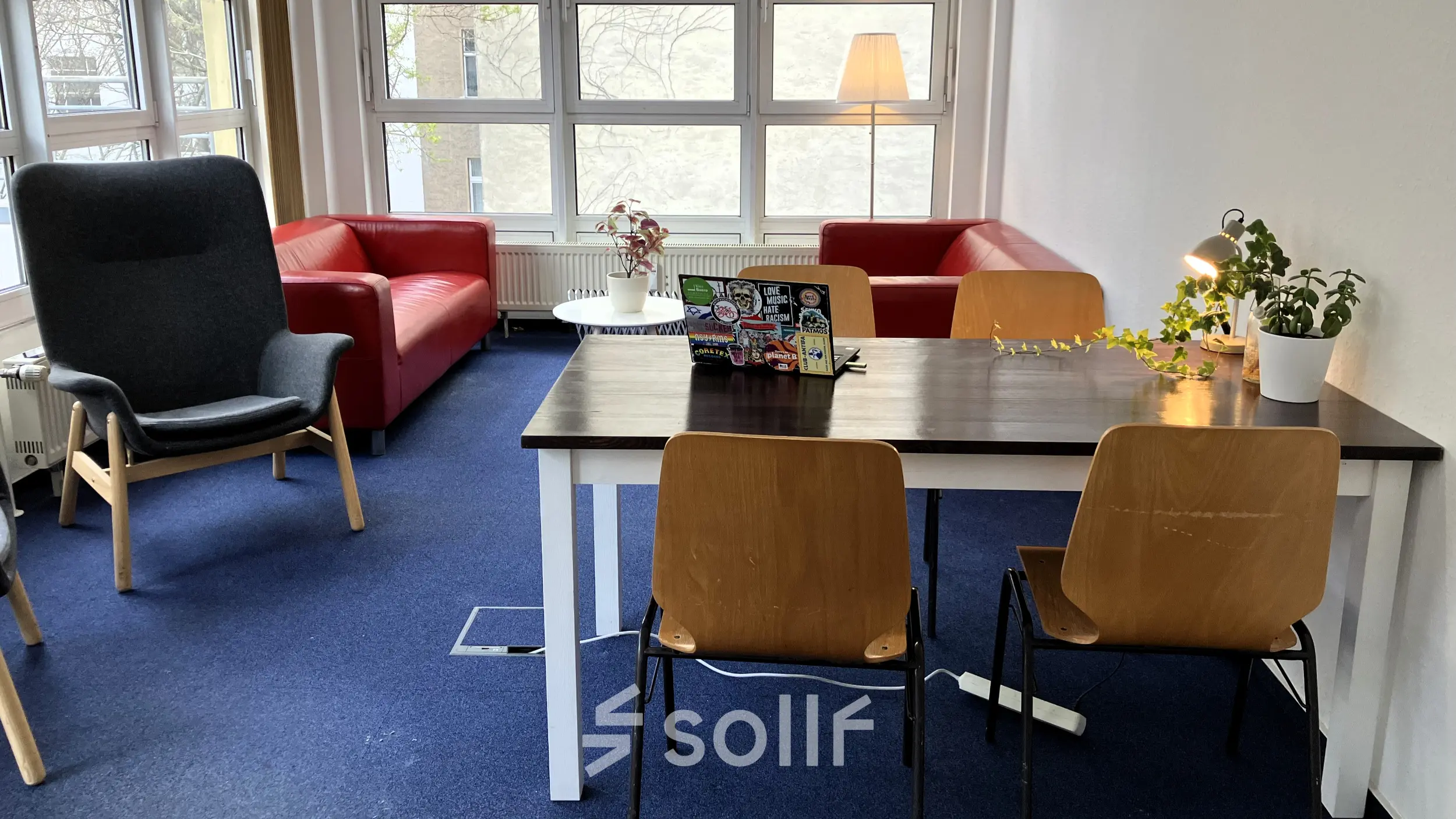 Gemütlicher Büroraum in Berlin Kreuzberg mit Tisch, Stühlen und Sofa für eine entspannte Arbeitsatmosphäre. Bürofläche mieten leicht gemacht.