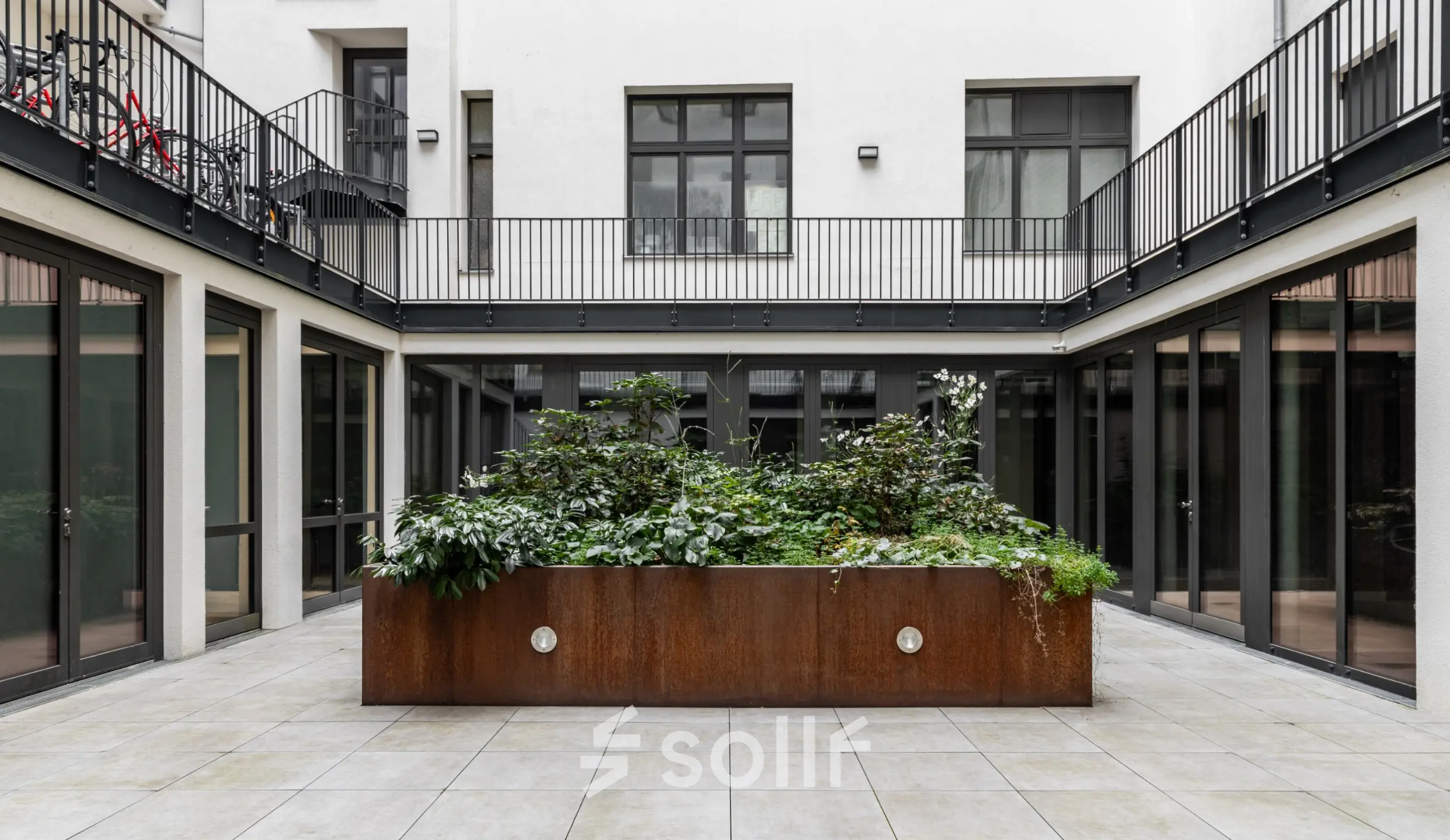 Innenhof mit grünem Pflanzbeet in der Chausseestraße 29, ideal für die Pause beim Büro mieten oder Büroraum mieten in Berlin Kreuzberg.