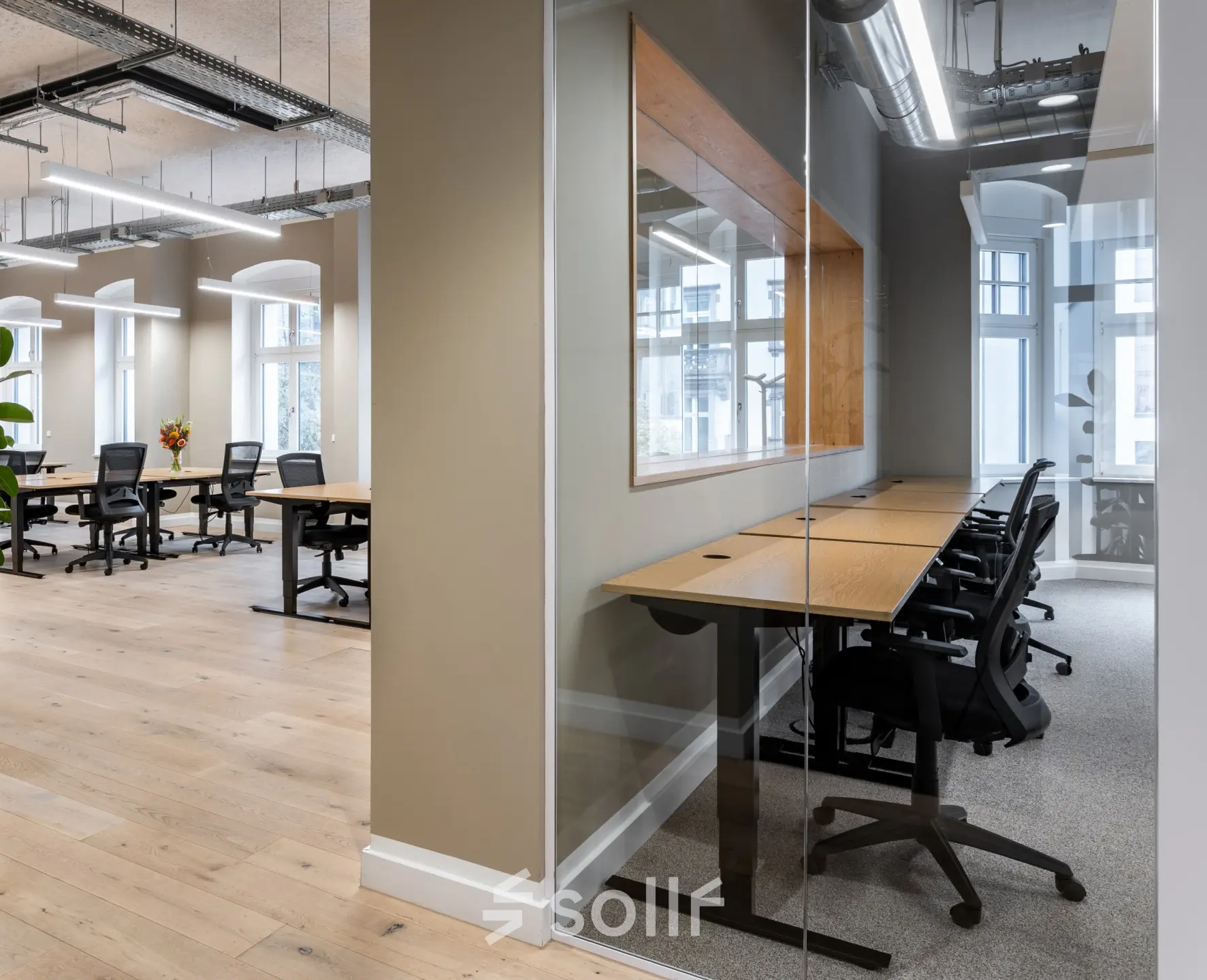 Moderne Bürofläche mit mehreren Arbeitsplätzen und Holzfußboden in der Chausseestraße 29, Berlin Kreuzberg. Ideal für flexible Arbeitsstile. Perfekt, um Büroraum mieten zu können.