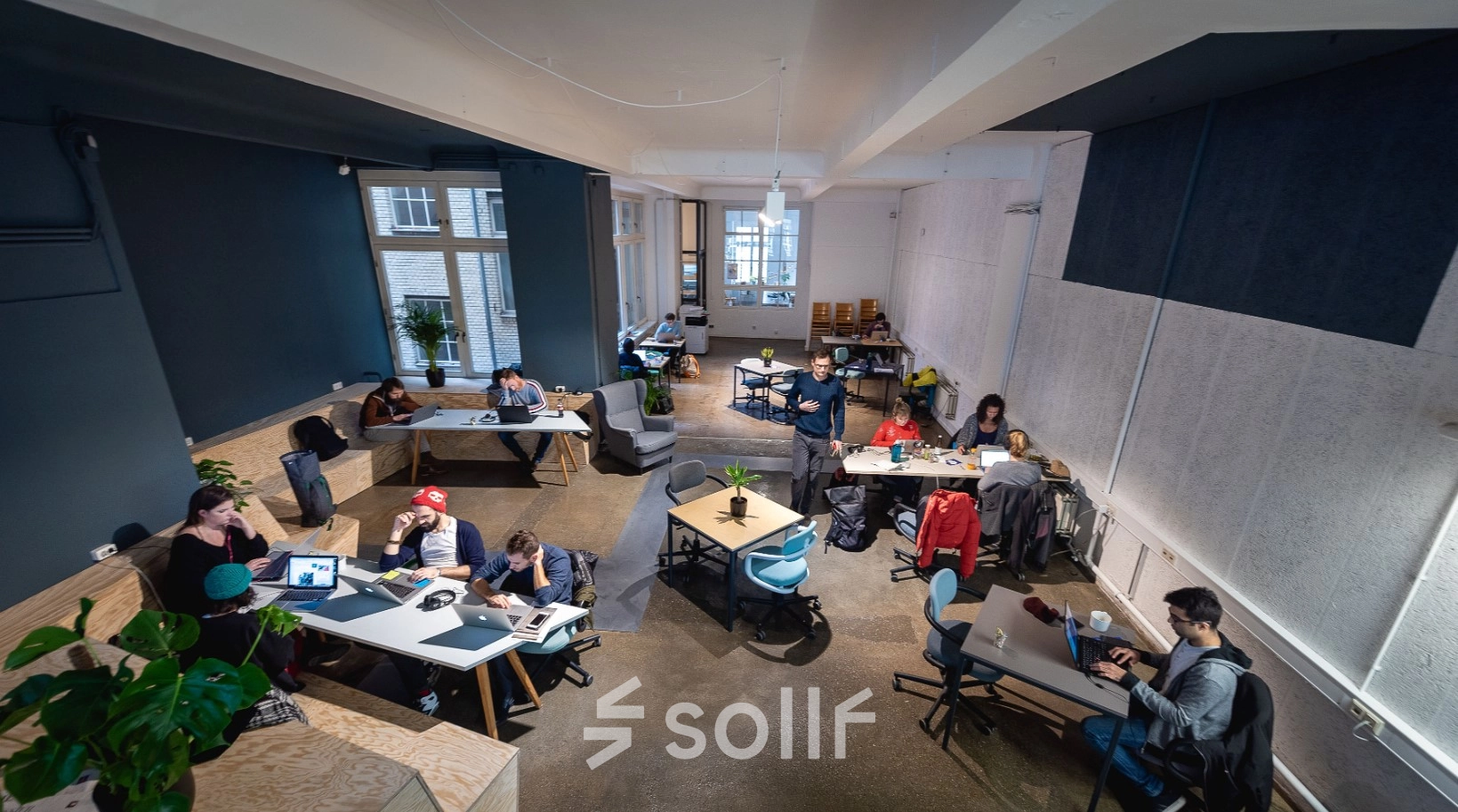 Modernes Büro in Berlin Kreuzberg, Rudi-Dutschke-Straße 23, zeigt verschiedene Bereiche mit Schreibtischen und Personen bei der Arbeit. Ideal für büroraum mieten mit flexibler Nutzung.