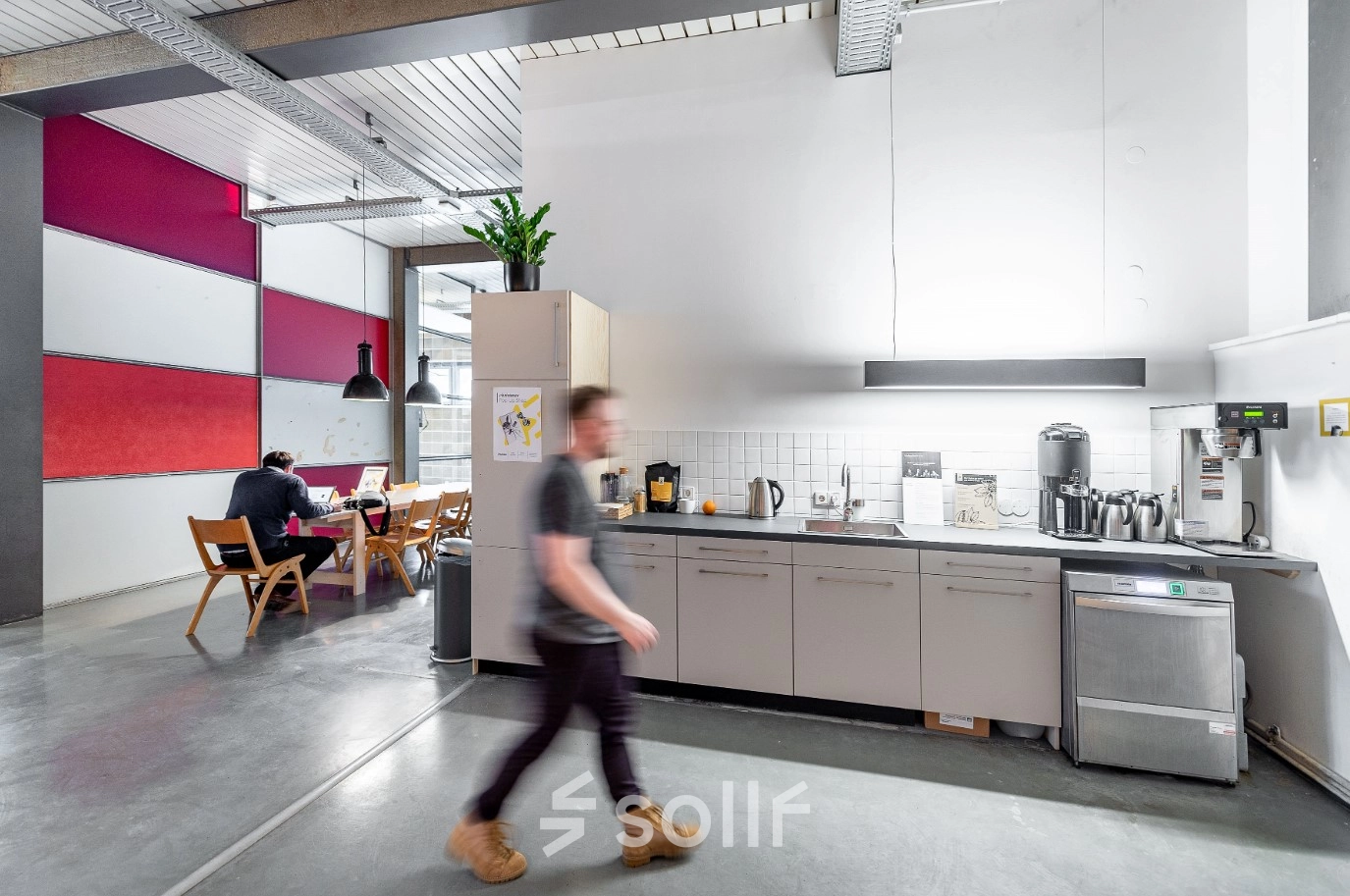 Moderner Büroraum in Berlin Kreuzberg mit funktionaler Küche und Menschen, die arbeiten. Ideal, um Bürofläche oder Büroraum zu mieten.