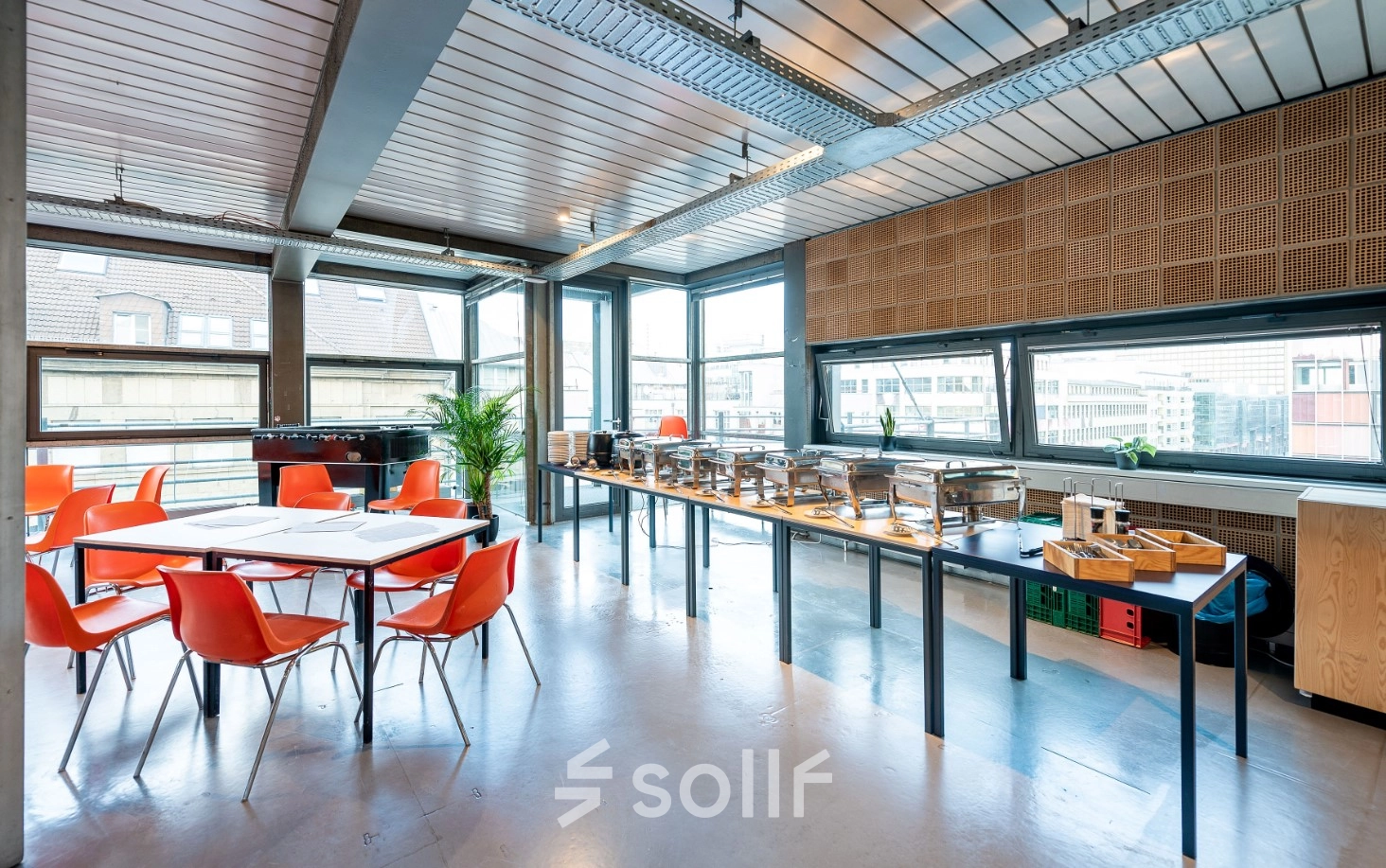 Heller Büroraum mit großen Fenstern in der Rudi-Dutschke-Straße 23, Berlin Kreuzberg, ideal zum Bürofläche mieten mit modernen orangen Stühlen und Tischgestaltung.