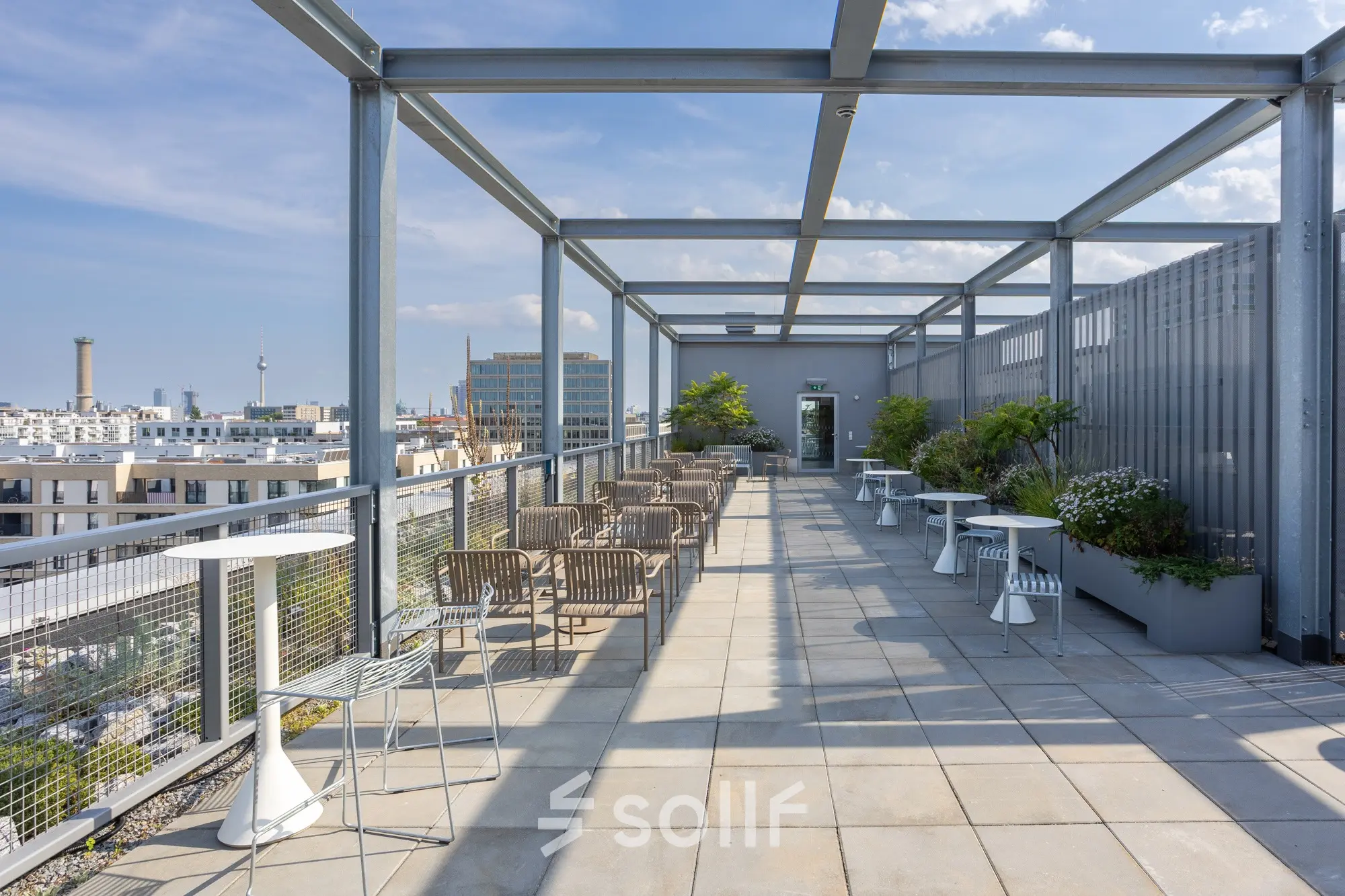 Geräumige Dachterrasse in Berlin Mitte mit Sitzgelegenheiten und Blick auf die Skyline, ideal für eine kreative Pause oder informelle Treffen.