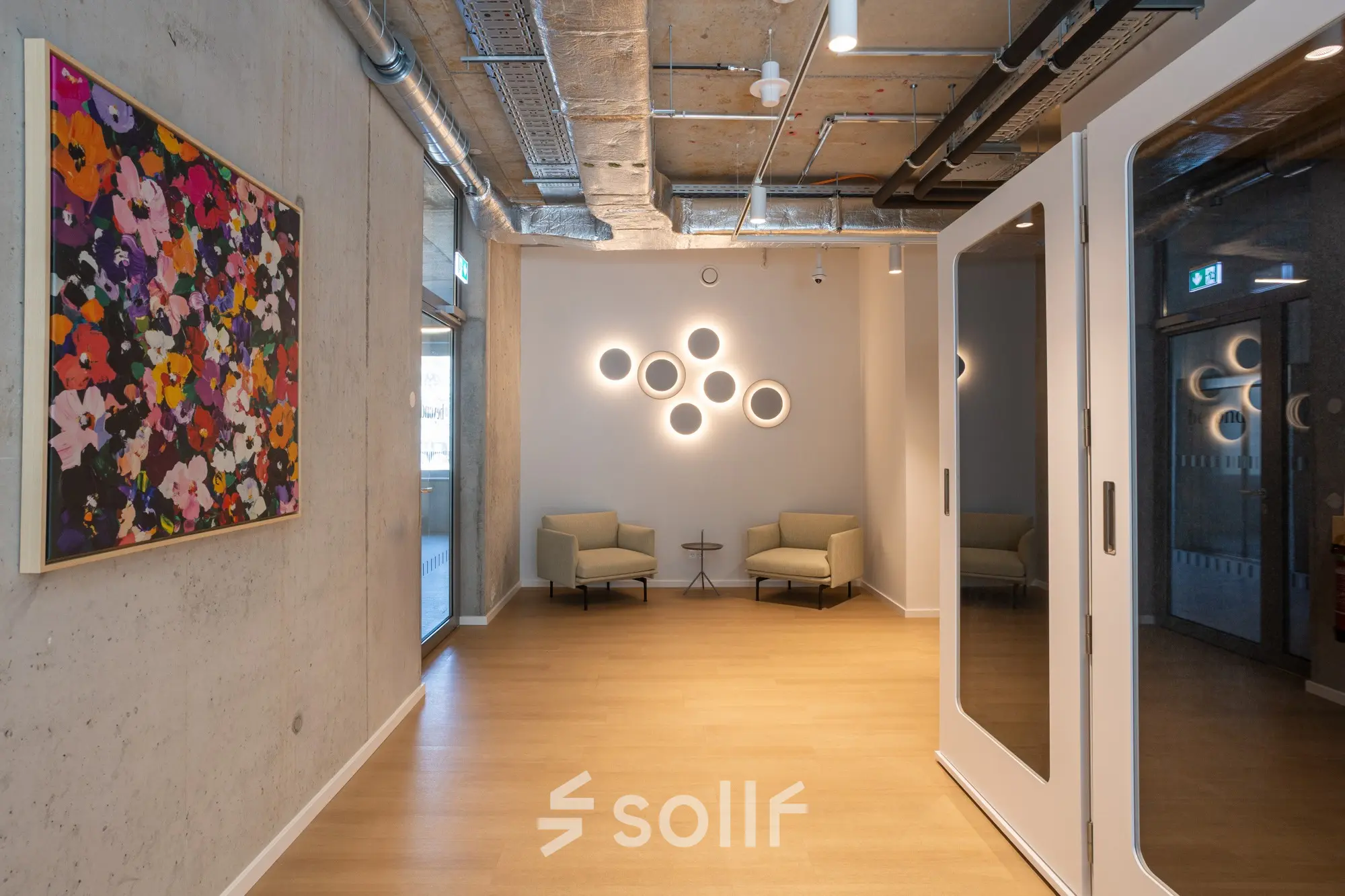 Moderner, möblierter Büroraum in Berlin Mitte, Heidestraße 34, mit zwei Sesseln und künstlerischer Dekoration - ideal zum Bürofläche mieten.