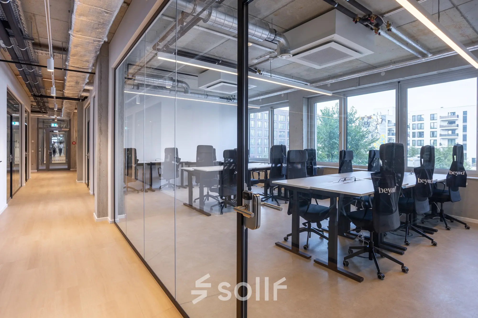 Moderner Büroraum mit Glaswänden in Berlin Mitte, ideal zum Büro mieten. Die Bürofläche bietet hochwertige Stühle und Tische, viel Tageslicht und eine klare, professionelle Umgebung.