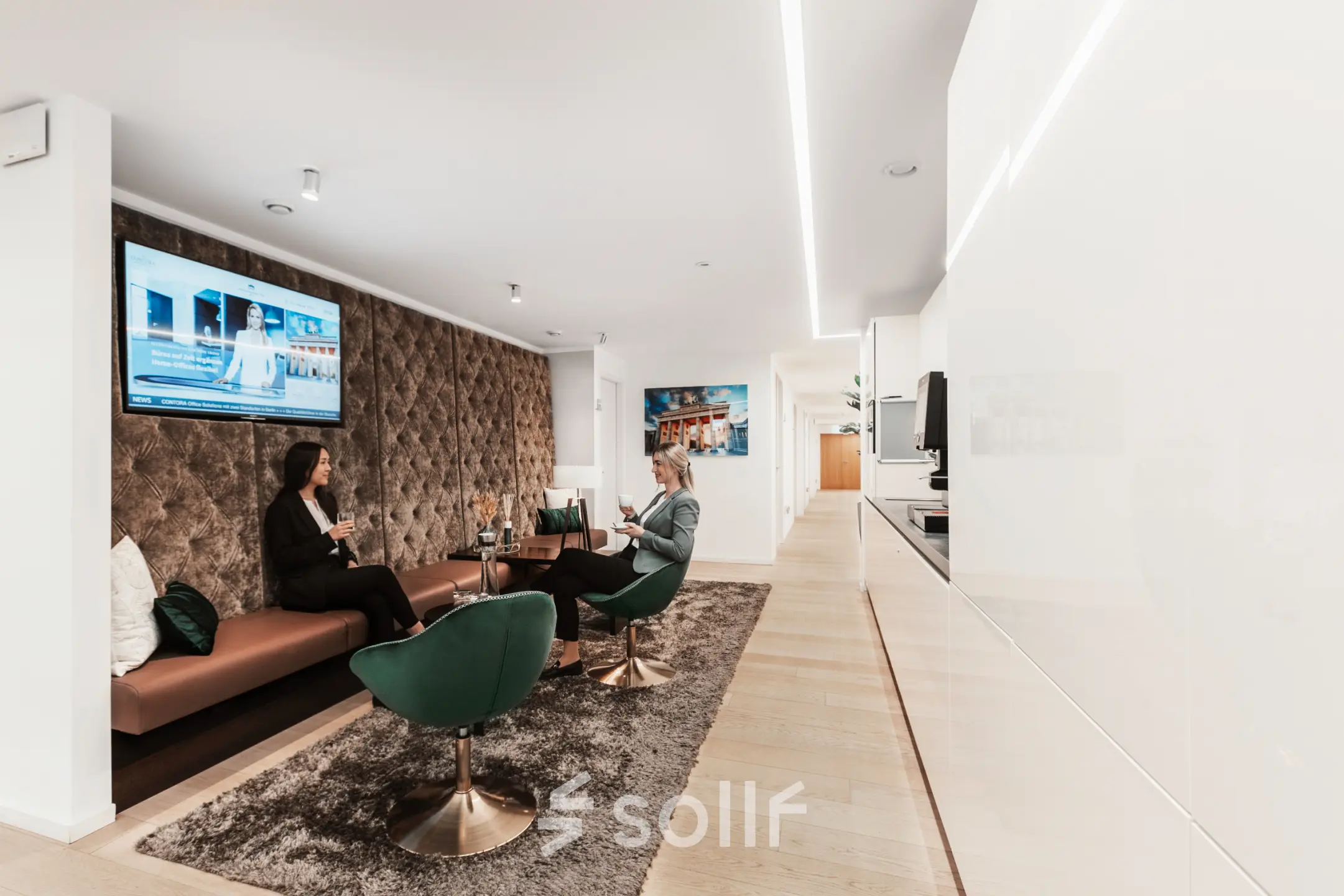 Moderner Büroraum am Pariser Platz 6a, Berlin Mitte, mit stilvollen Sitzgelegenheiten und Personen in einem Gespräch. Ideal, um Bürofläche zu mieten.