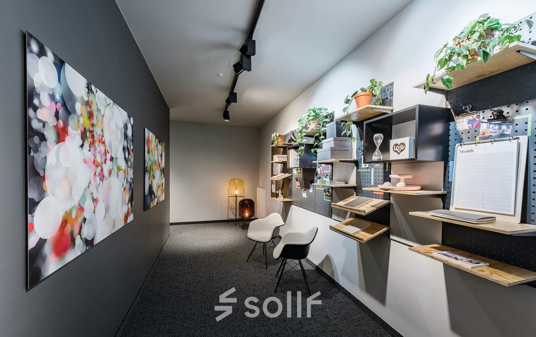 Ein stilvoller Büroraum in Berlin Mitte, Unter den Linden 26-30, mit kreativer Wanddekoration und zwei Stühlen für informelle Gespräche. Ideal für dynamische Teams, die Bürofläche mieten möchten.