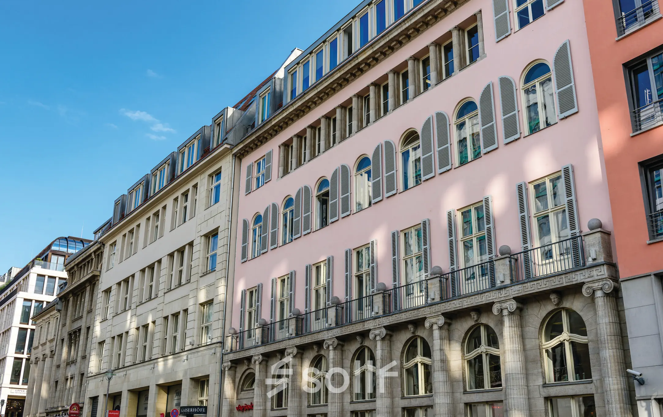 Die Fassade eines Bürogebäudes in Berlin Mitte, Unter den Linden 26-30, ideal für alle, die Bürofläche mieten möchten. Klassische Architektur mit hohen Fenstern.