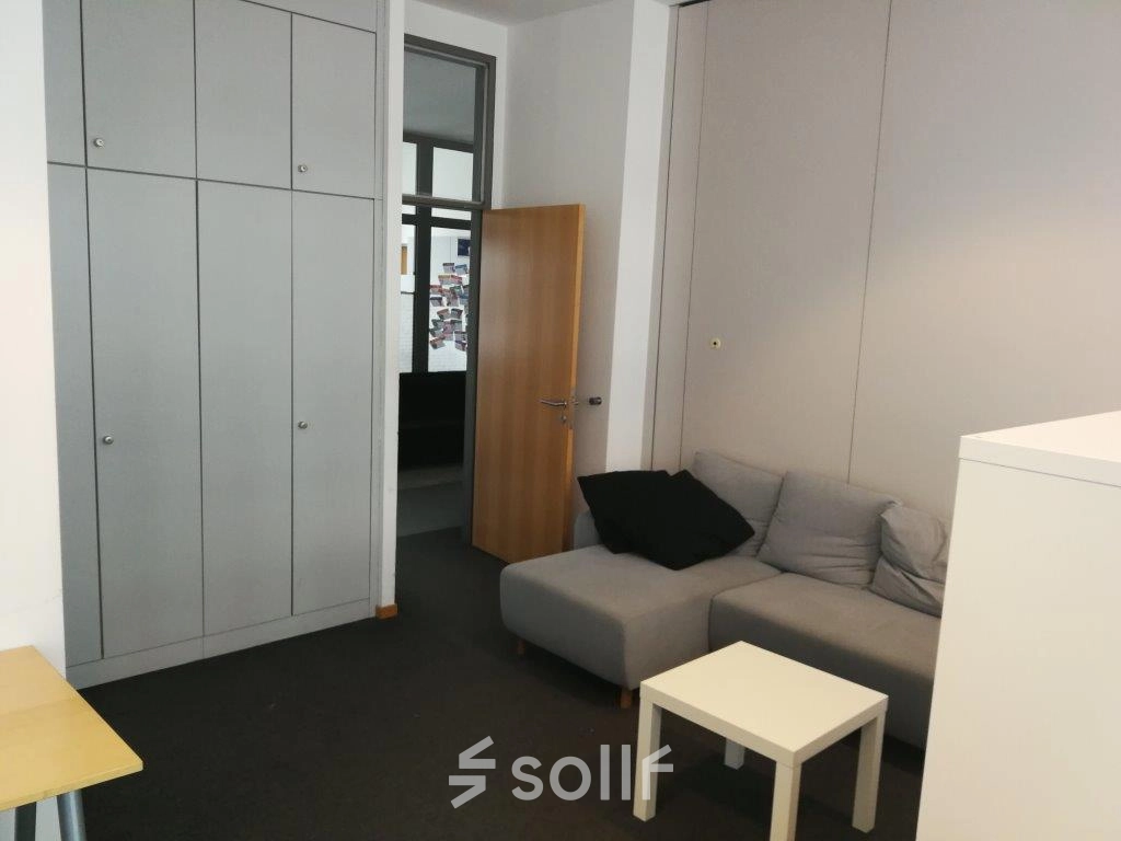 Kompakter Büroraum in Berlin Mitte, Zinnowitzer Straße 1, mit grauer Couch und kleinem Tisch, ideal zum Büro mieten.