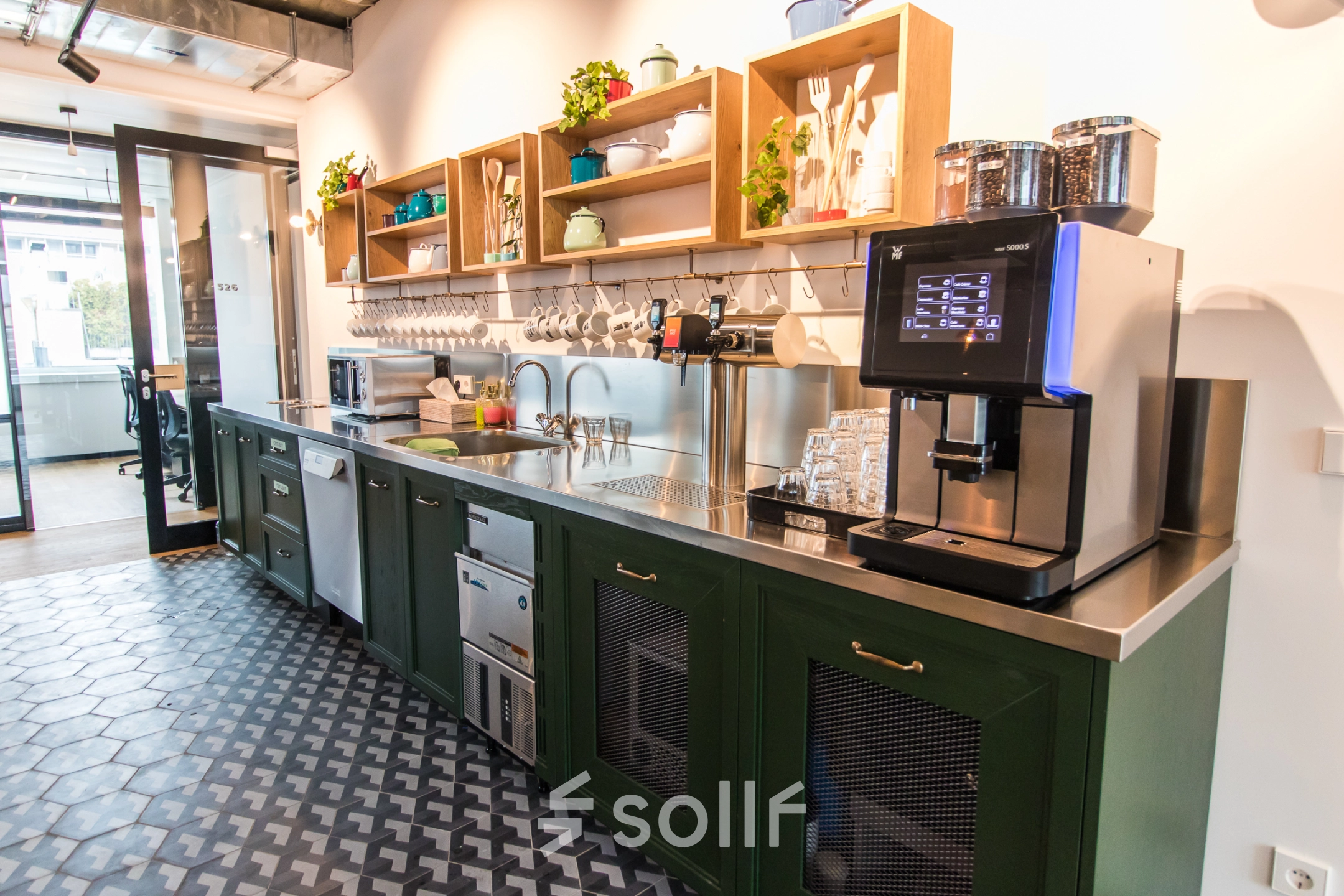 Moderne Büro-Pantry in der Herzogspitalstraße 24, München Altstadt mit stilvollen, offenen Regalen und einem Kaffeeautomaten, ideal für Mieter, die büroraum mieten wollen.