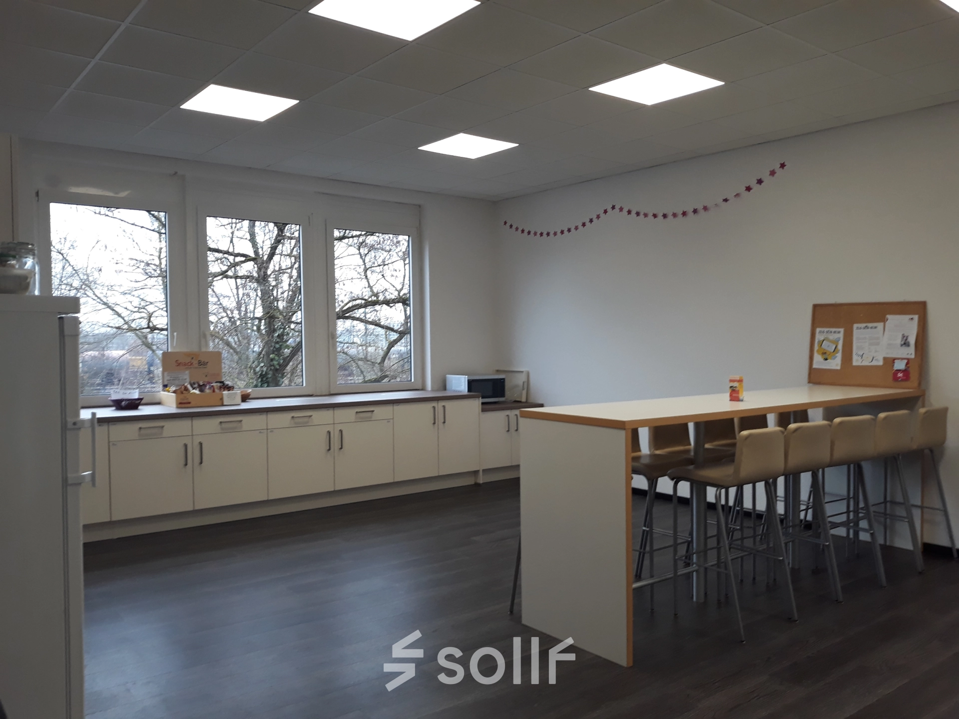 Heller Büroraum in München Pasing mit großen Fenstern und minimalistischem Mobiliar, ideal für Pausen. Perfekt für alle, die Bürofläche mieten oder Büroraum mieten möchten.