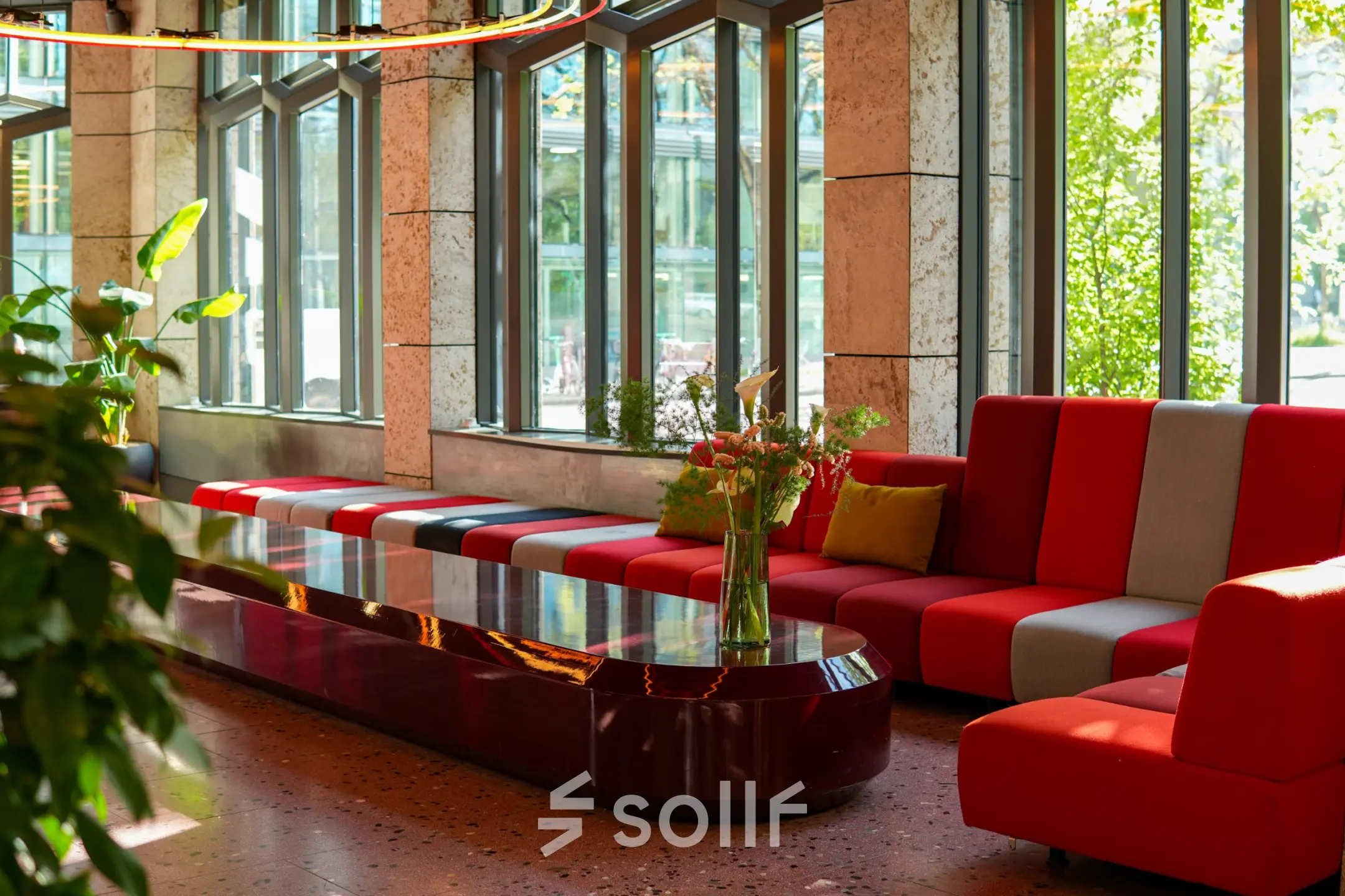 Modern eingerichteter Lounge-Bereich mit farbenfrohen Sitzgelegenheiten und großen Fenstern am Ernst Nobs Platz 1 in Zürich City. Ideal für Mieter, die eine Bürofläche oder Büroraum mieten möchten.