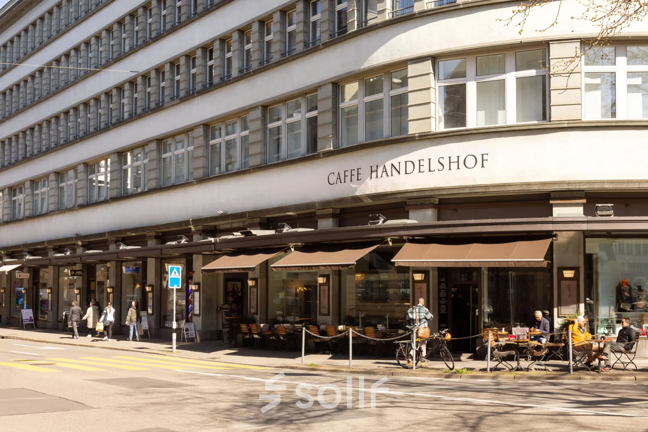 Außenansicht eines Bürogebäudes an der Uraniastrasse 31, Zürich City, mit Straßencafé und vorbeigehenden Menschen.