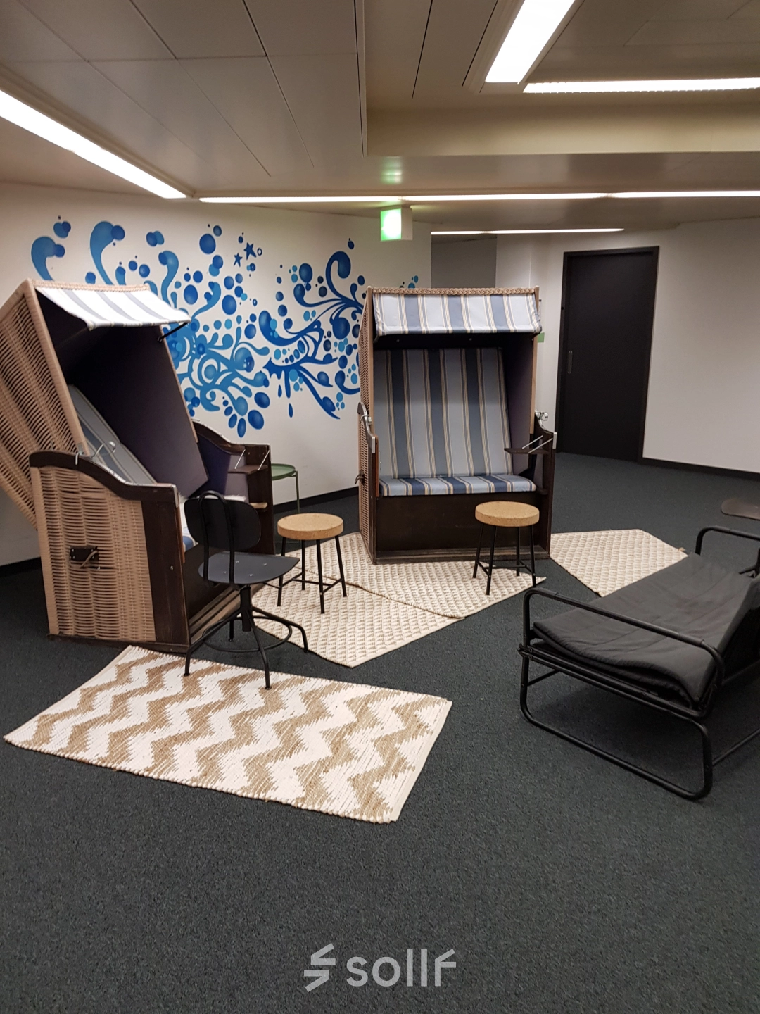 Kreativer Büroraum mit Strandkorbmöbeln und moderner Wandgestaltung in Zürich Enge, ideal für ein außergewöhnliches Büro mieten.