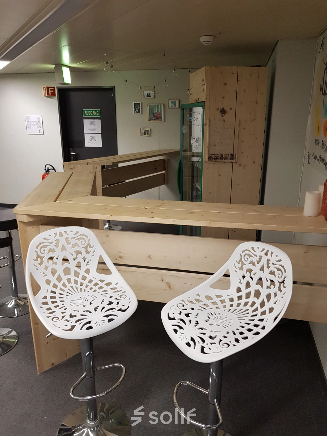 Moderner Büroraum am Mythenquai 26 in Zürich Enge mit stilvollem Thekenbereich und weißen Stühlen. Perfekt, um Büroflächen oder Büroräume zu mieten.