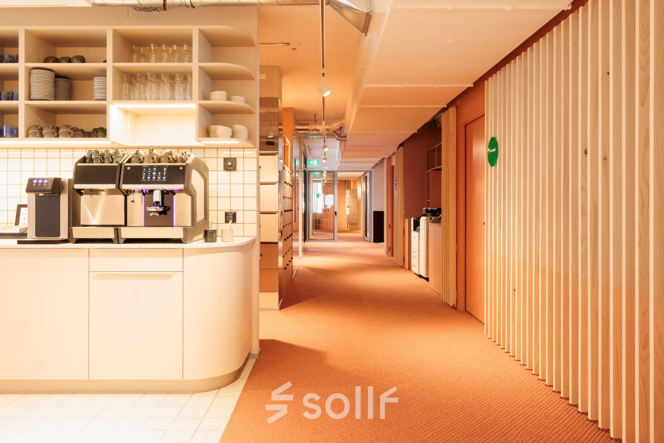 Gemütlicher Büroraum in der Stockerstrasse 33, Zürich Enge; möbliert mit Pantrybereich, perfekt für büro mieten. Heller Gang mit Regalen und Kaffeemaschine.