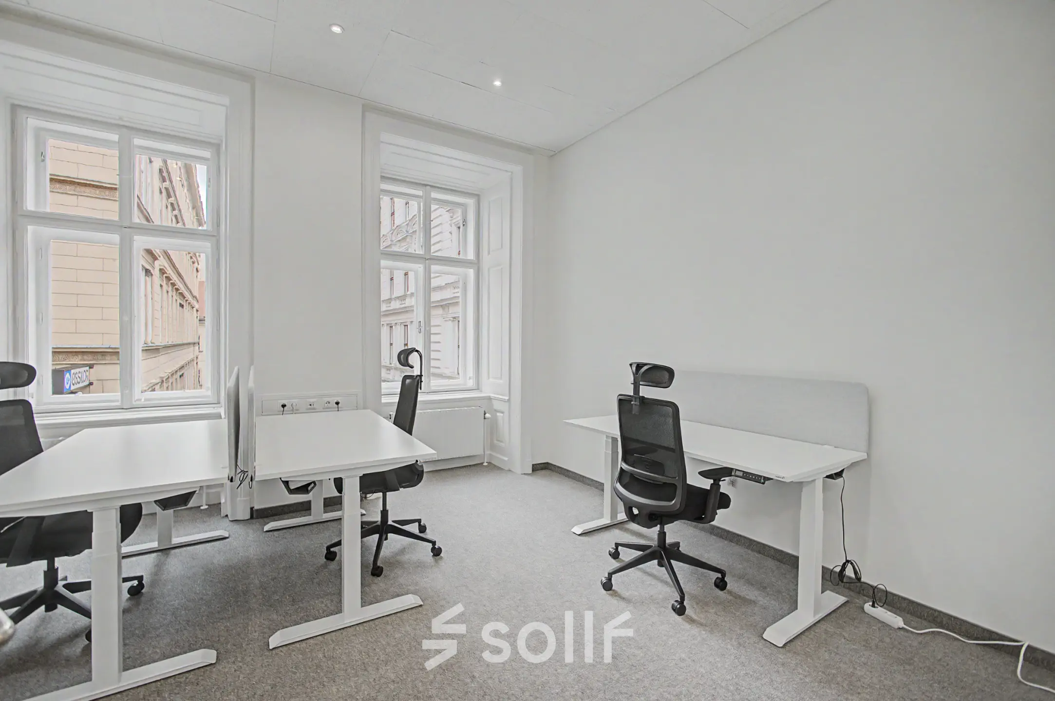 Bright office space at Wollzeile 11, 1010 Vienna, featuring ergonomic chairs and desks near large windows. Ideal for office space rental with natural light.