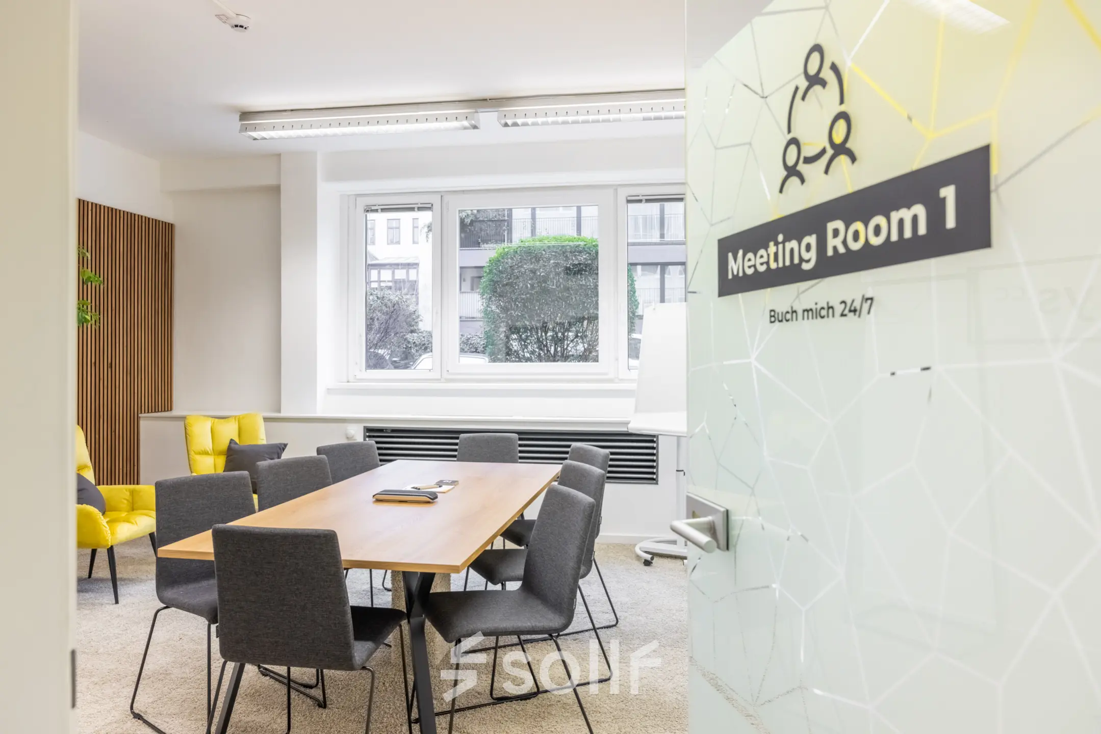 Bright office meeting room available for rent at Wohllebengasse 12/14 in 1040 Vienna. Features modern furnishings and large window providing natural light.