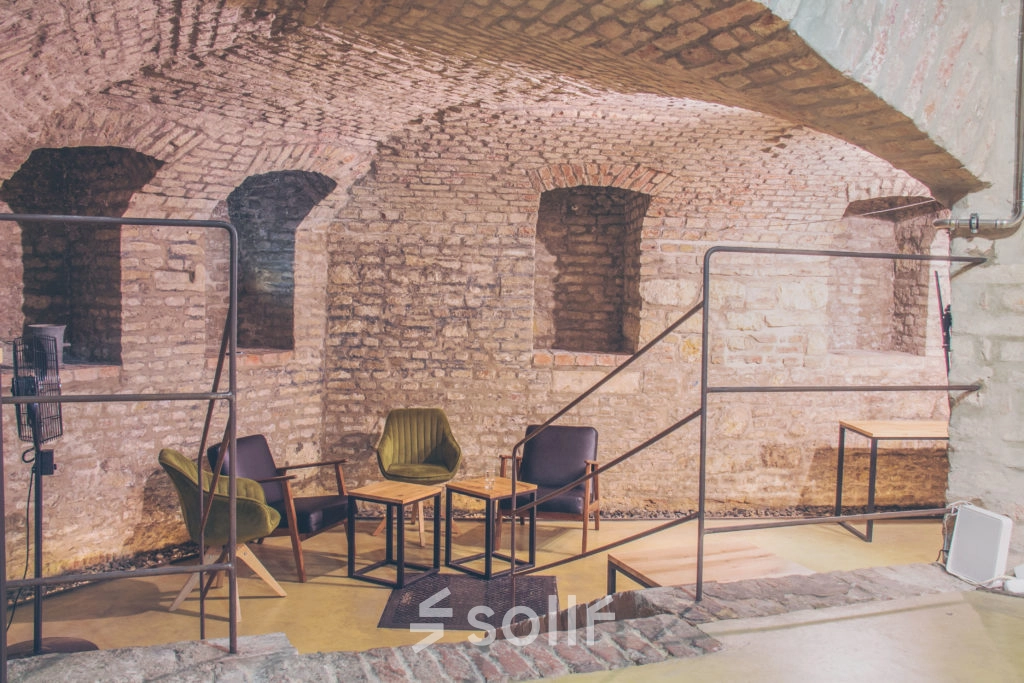 Cozy office space with exposed brick walls and modern seating at Zimmermanngasse 8, 1090 Vienna, suitable for rent office space.