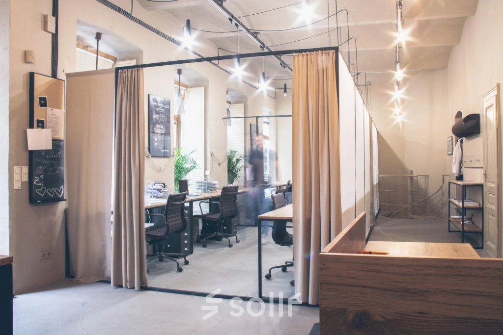 Furnished office space at Zimmermanngasse 8, 1090 Vienna, featuring an open workspace with several desks and chairs, ideal for office space rental in a professional setting.