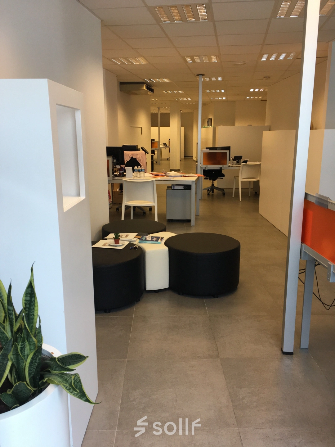 Interior view of office space at Keizersplein 24, Aalst België featuring desks and chairs suitable for office space rental. A few people are engaged in business activities.