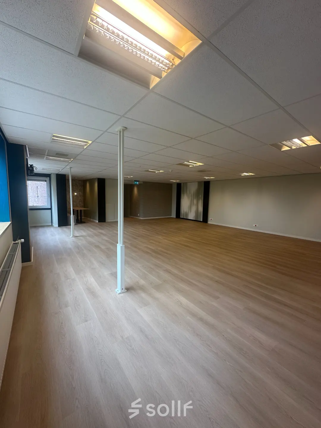Spacious unfurnished office interior at Hollandse Kade 38, Abcoude, featuring wooden flooring and ceiling lights, ideal for those looking to rent office space.