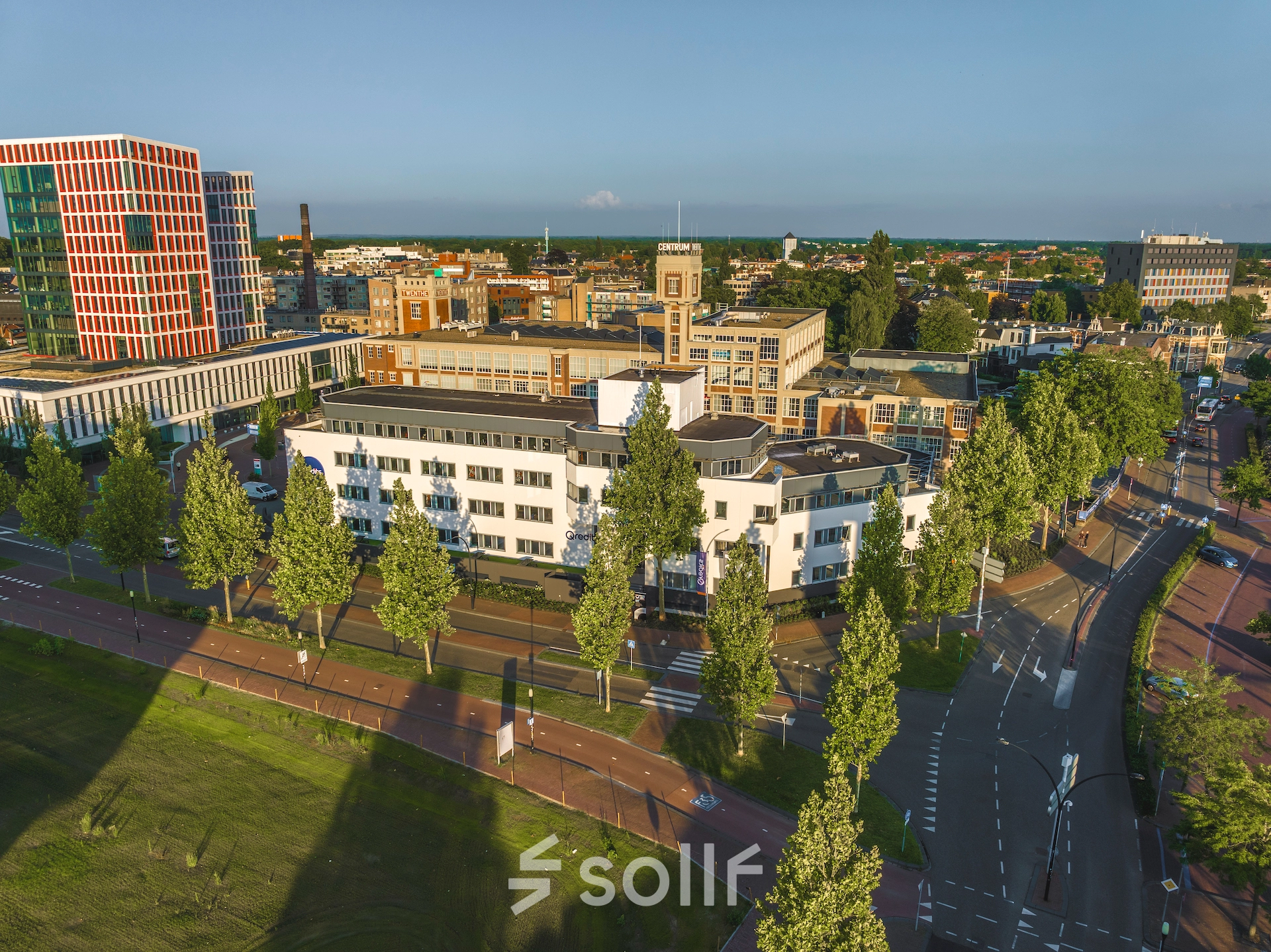 Aerial view of an office building at Egbert Gorterstraat 2-14, Almelo, surrounded by trees with roads running alongside. The space offers opportunities for office space rental in a bustling business district.