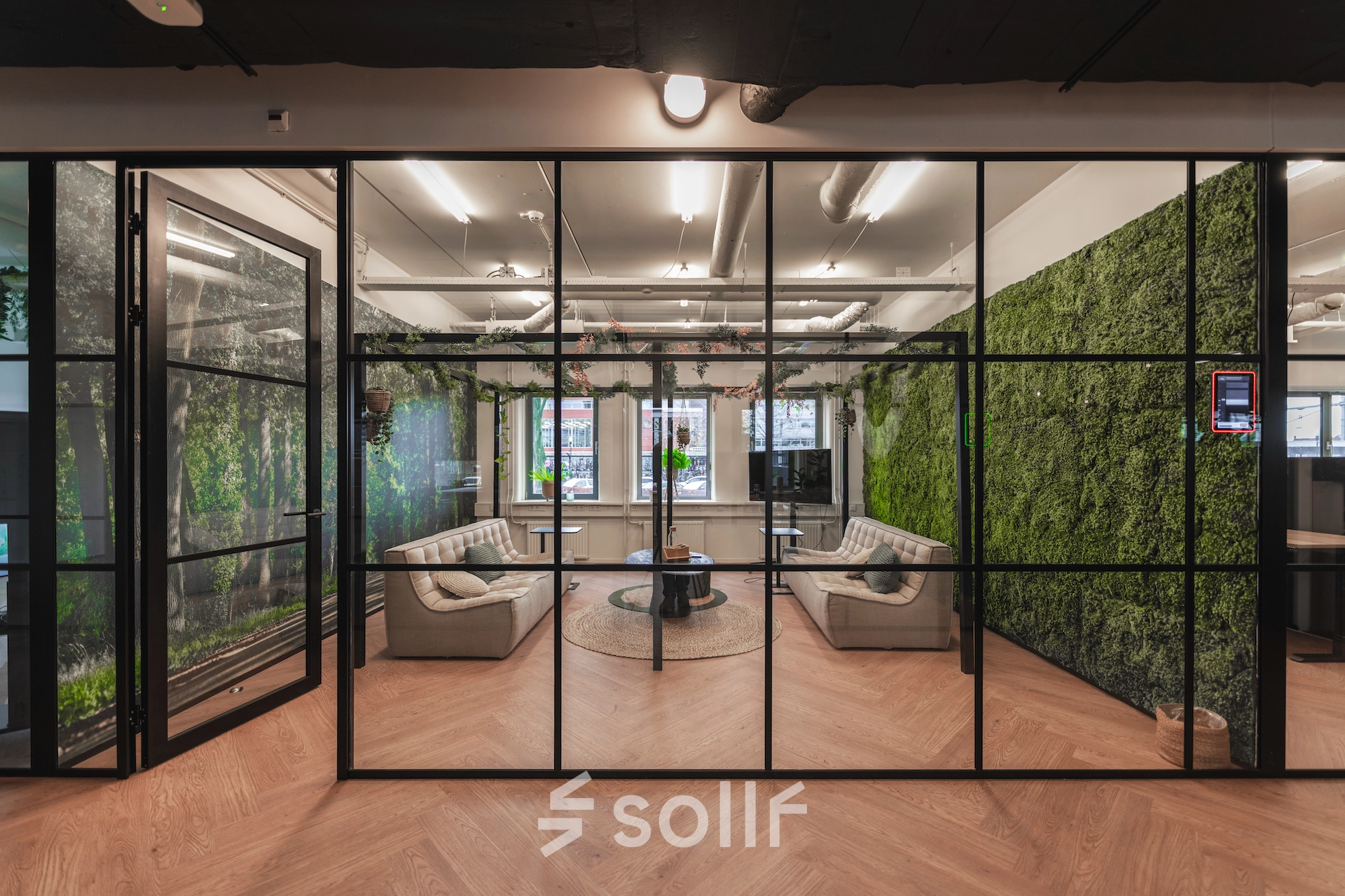 Modern office space rental featuring a stylish lounge area with comfortable seating and lush green walls at Egbert Gorterstraat 2-14, Almelo.