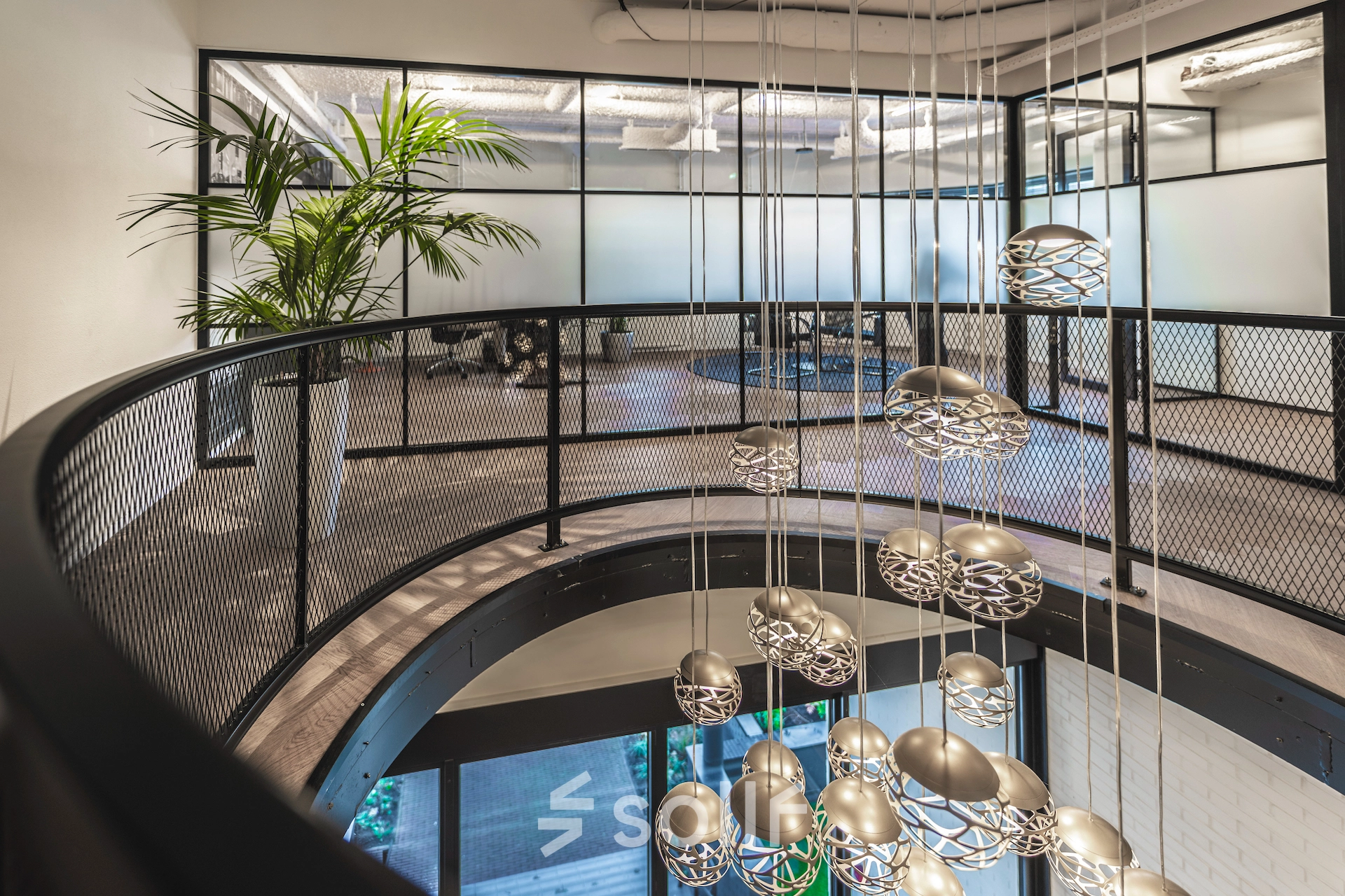 Modern office to rent featuring sleek glass walls, stylish lighting fixtures, and a contemporary open floor plan on Egbert Gorterstraat 2-14, Almelo.