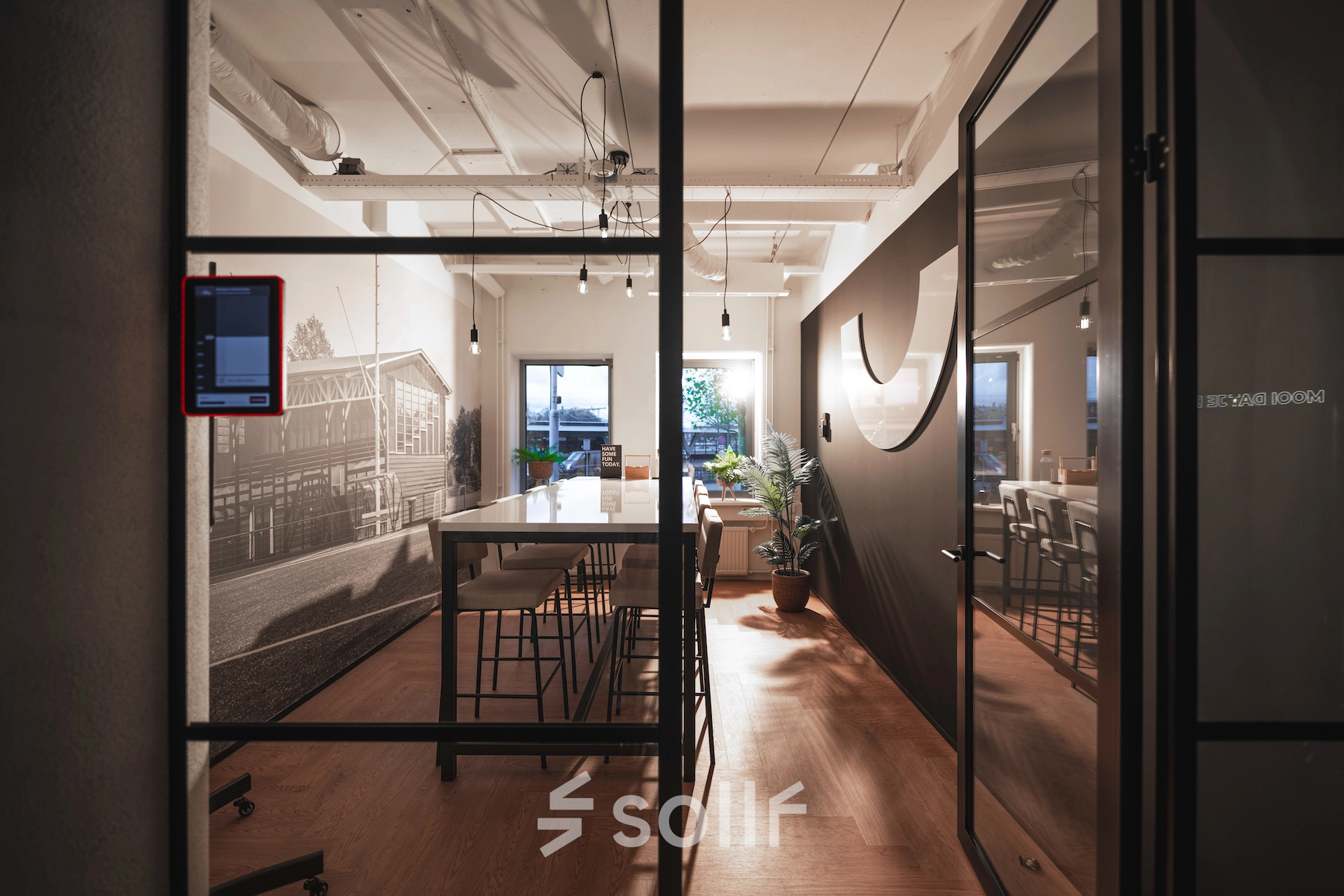 Modern office interior at Egbert Gorterstraat 2-14 in Almelo featuring a long table and high stools, suitable for dynamic meetings or as a collaborative workspace. Ideal for office space rental.