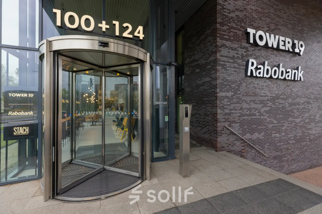 Entrance to office space rental at Landdrostdreef 124, Almere Stad, featuring a modern revolving door and sleek signage.