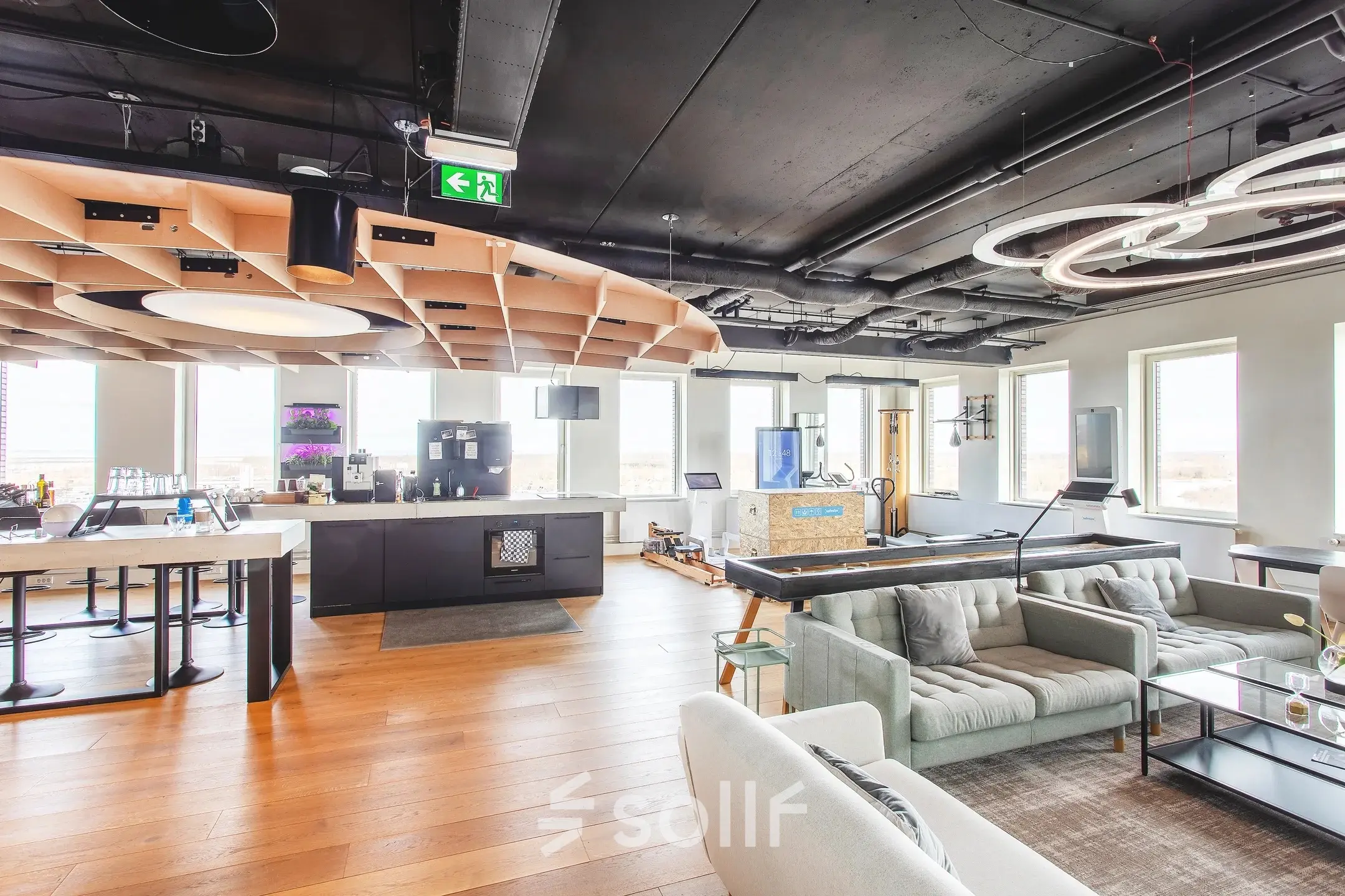 Modern furnished office space with open plan layout, featuring a lounge area and kitchen facilities, ideal for office space rental at Landdrostdreef 124, Almere Stad.