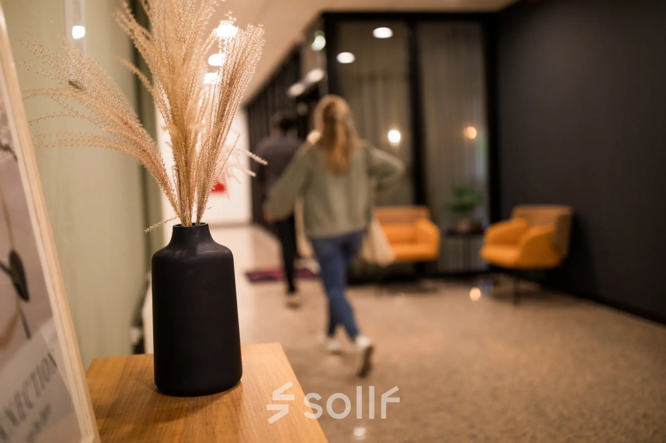 Cozy office entryway at Markerkant 1310 with contemporary decor and seating area. People walking through, illustrating active office space rental.