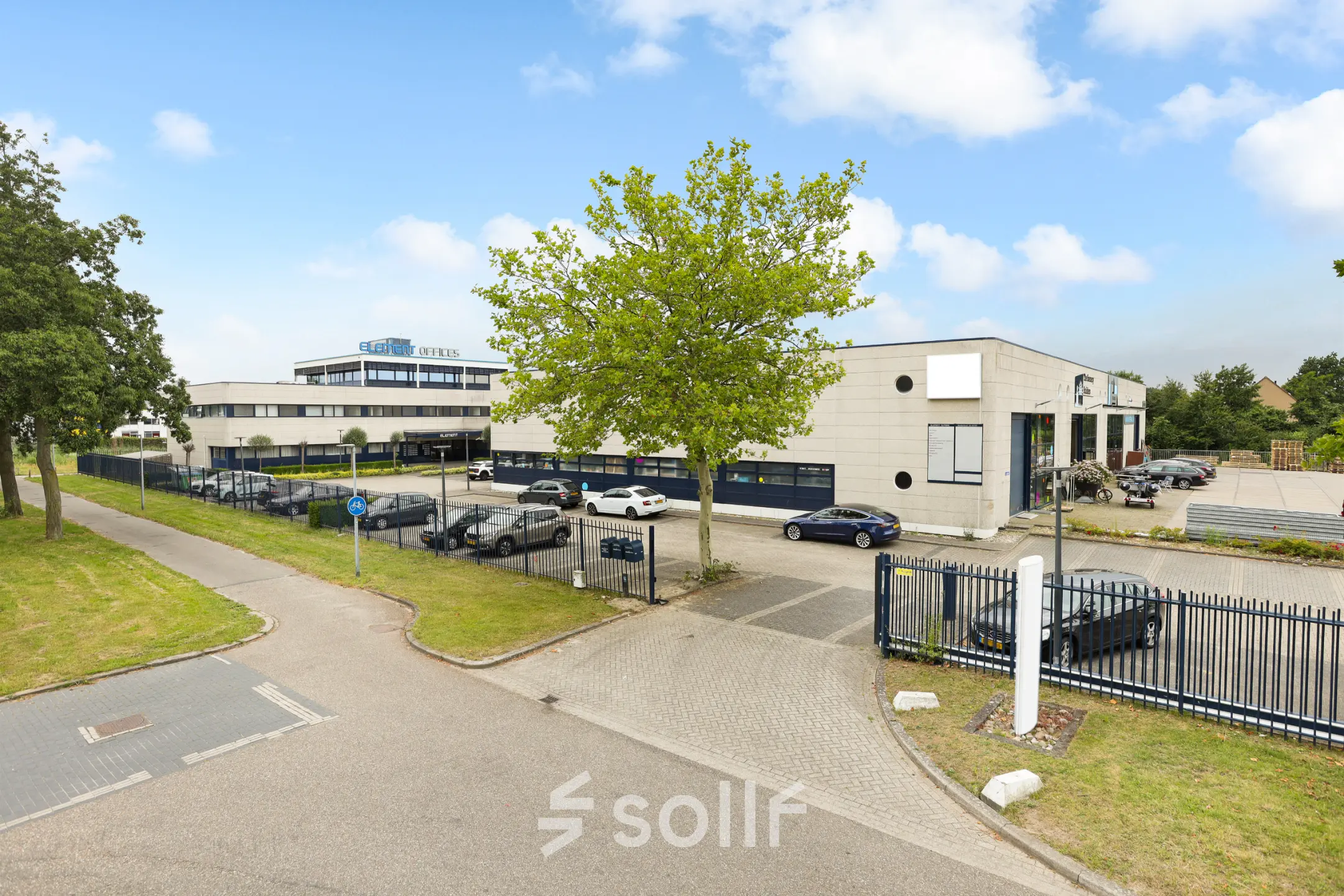 Exterior view of office buildings at Markerkant 1310, Almere Stad, showcasing ample parking and greenery, ideal for office space rental opportunities.