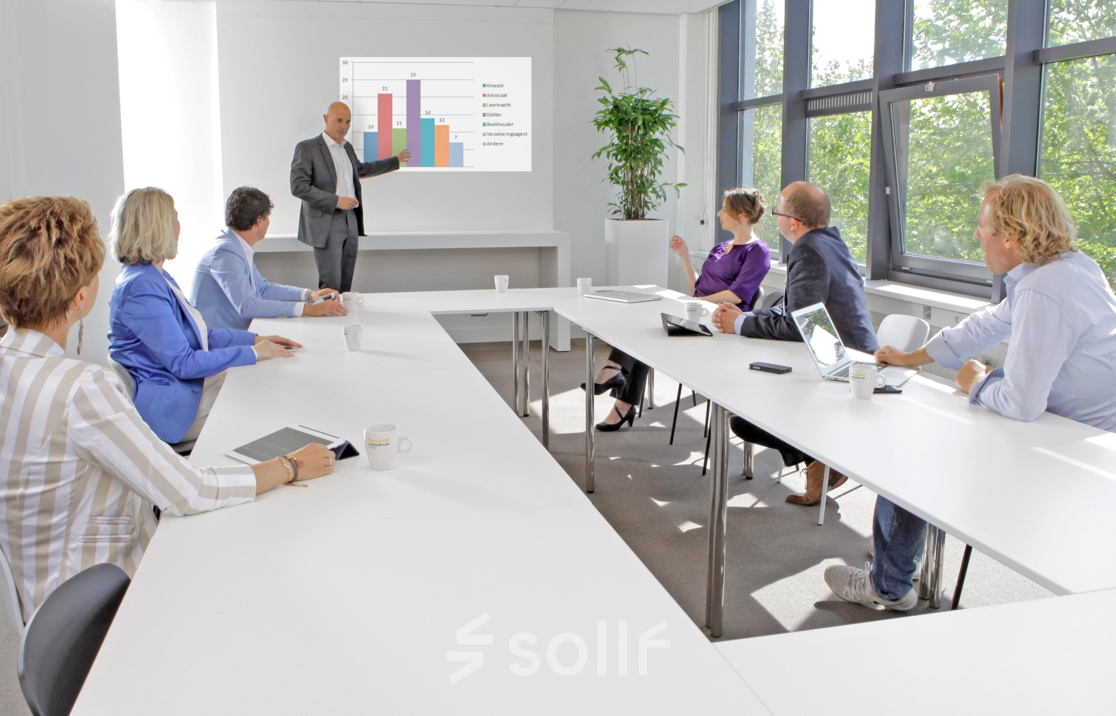 Office to rent at Europalaan 16, Alphen aan den Rijn. A team of professionals engaged in a meeting with digital presentations in a bright conference room featuring modern furnishings.