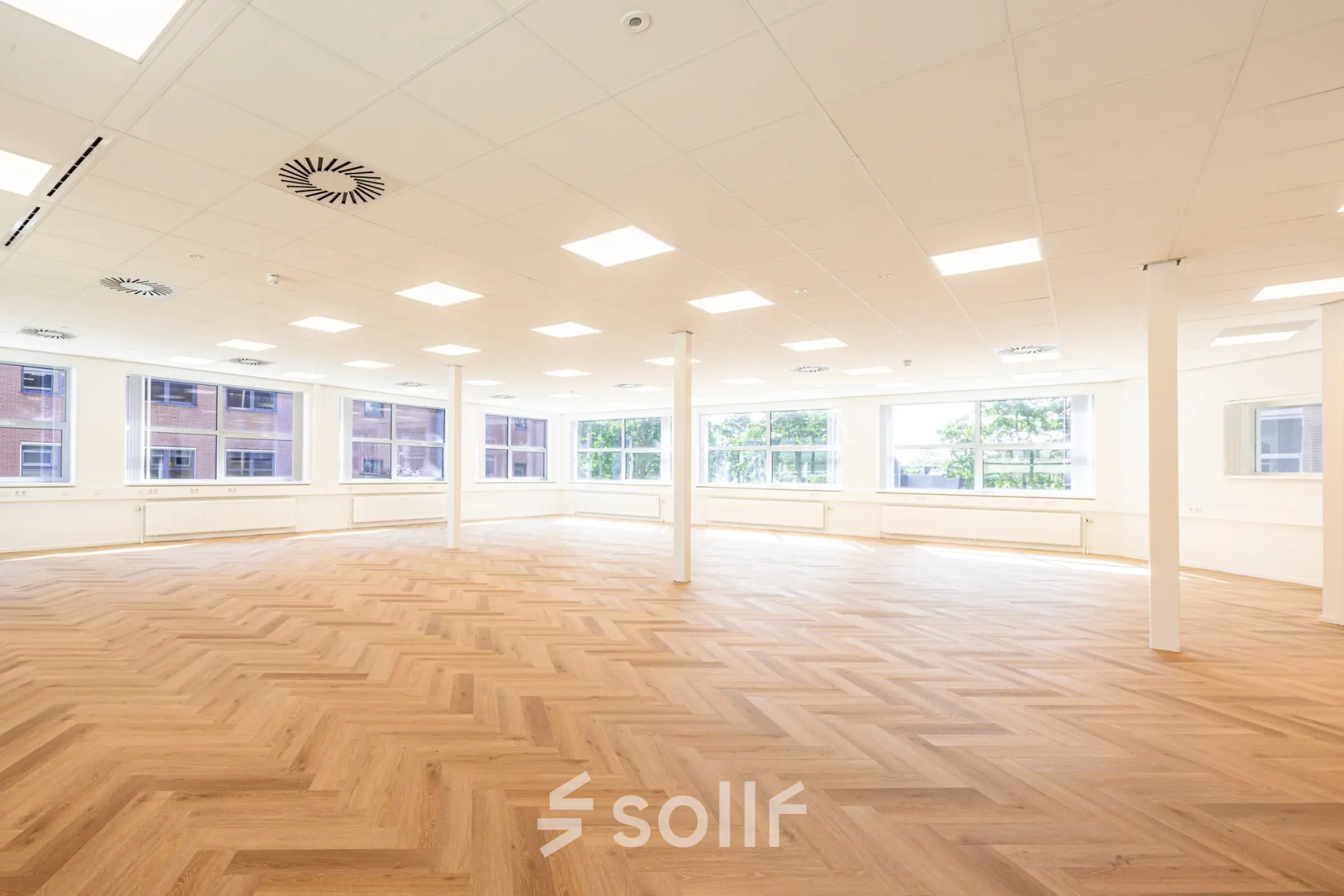 Bright office space with large windows and a wooden herringbone floor in Amersfoort Calveen for office space rental.