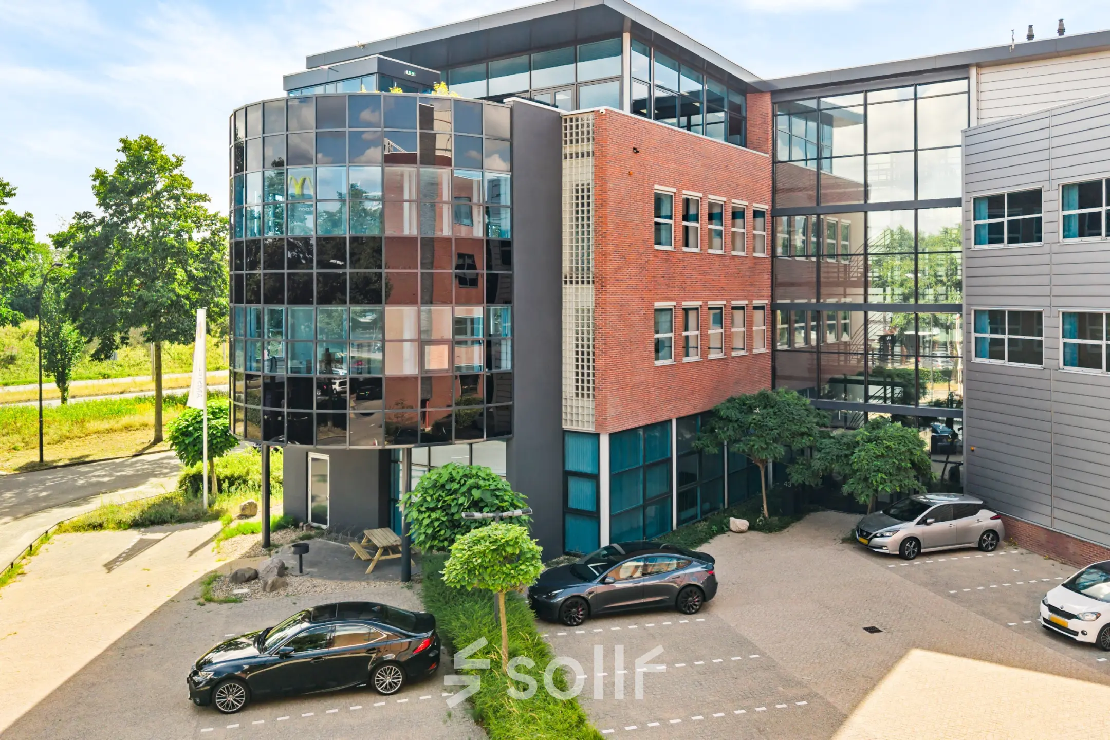 Exterior view of office building at Maanlander 43, Amersfoort Calveen with modern glass facade and parked cars.
