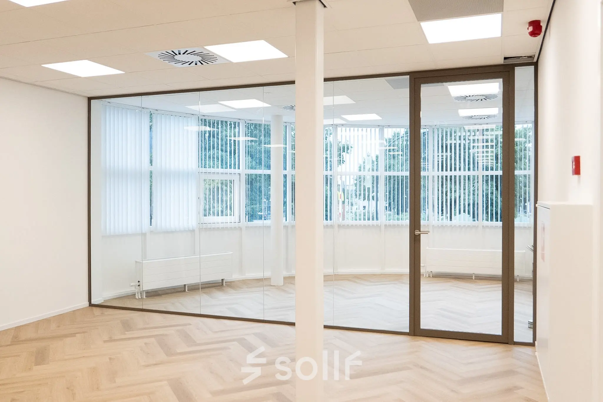 Empty office space at Maanlander 43, Amersfoort Calveen, featuring large windows and parquet flooring, ideal for office space rental.