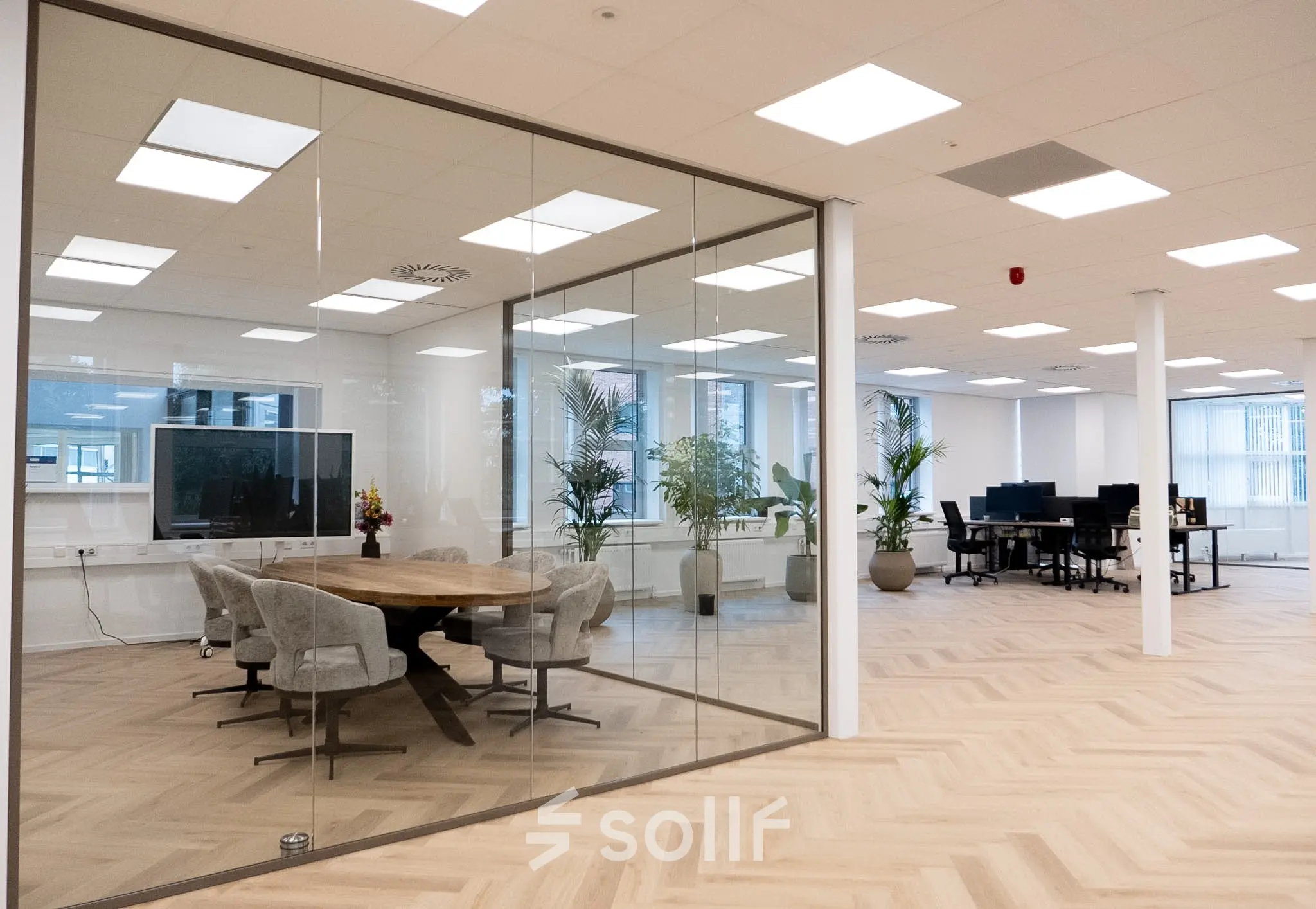 Bright office space rental at Maanlander 43, Amersfoort Calveen with open-plan design, glass-walled conference room, and modern furnishings.