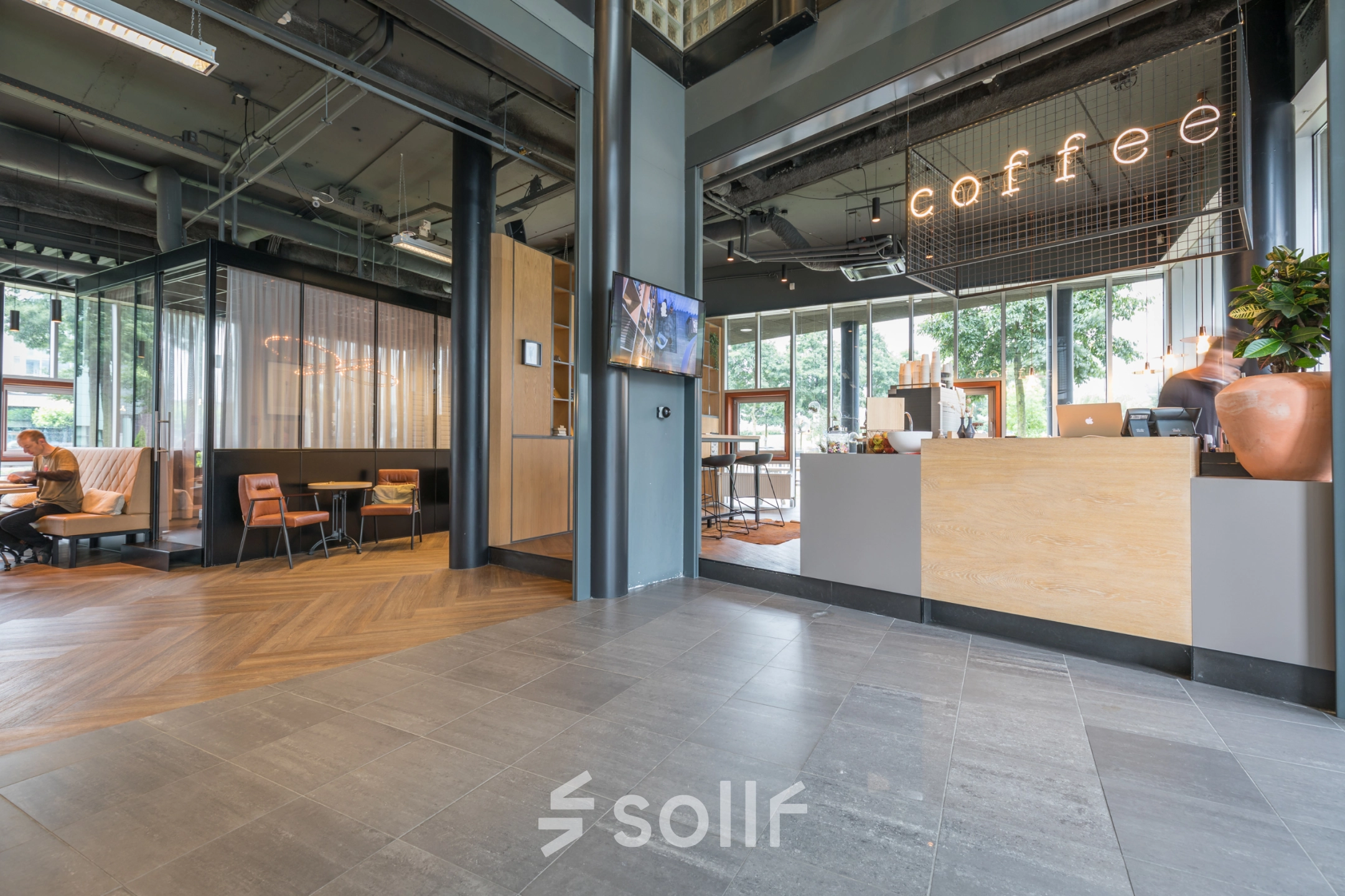 Modern office space rental at Maanlander 47 in Amersfoort Calveen featuring a welcoming area with seating and a coffee counter.